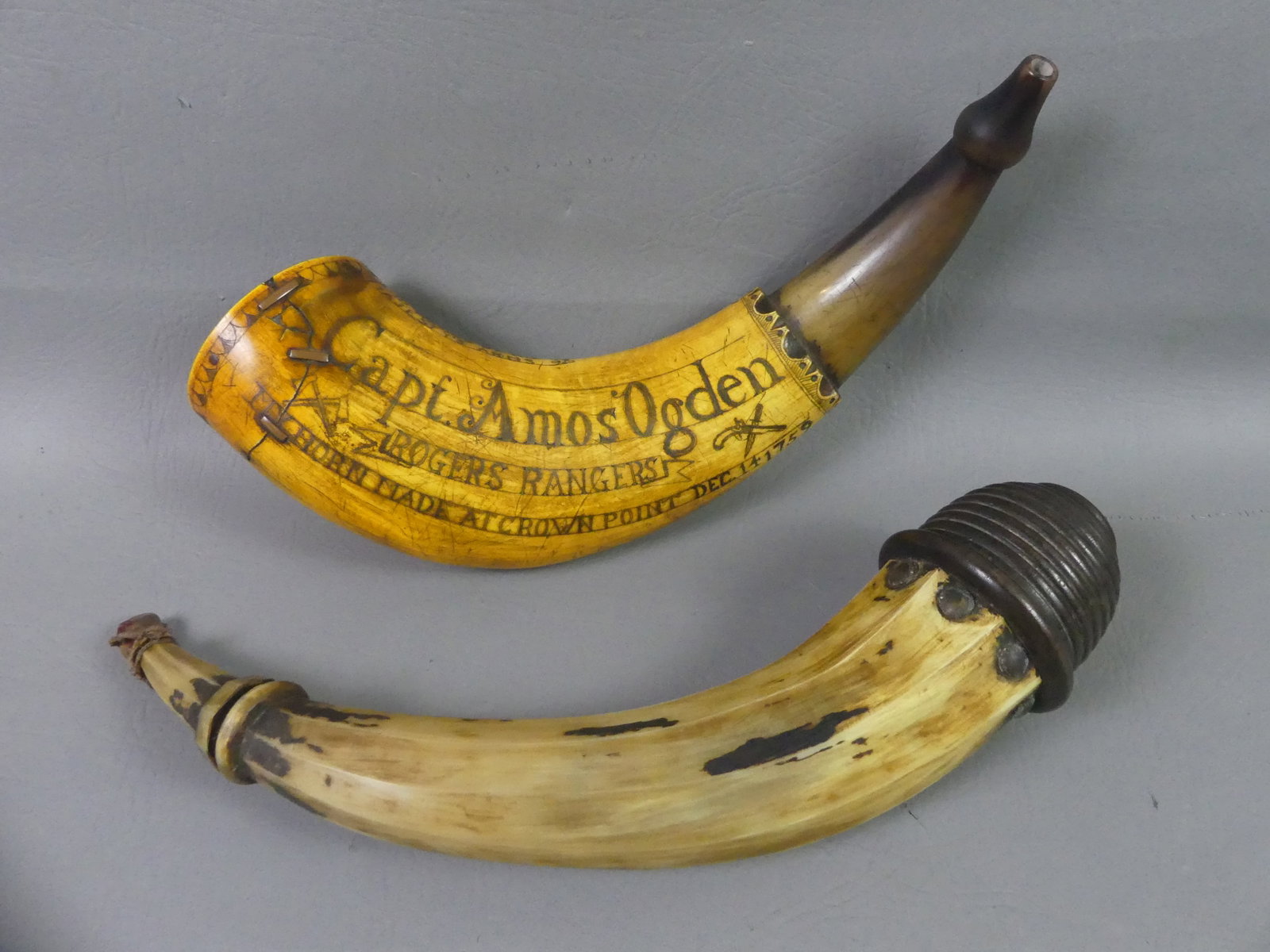 2 POWDER HORNS - ROGERS RANGERS 1759: Lot of 2 powder horns: elaborate scrimshaw horn for Capt. Amos Ogden, Rogers Rangers at Crown Point Dec. 14, 1759 with map showing destruction of the Indian population at St. Francis River. 12 in long