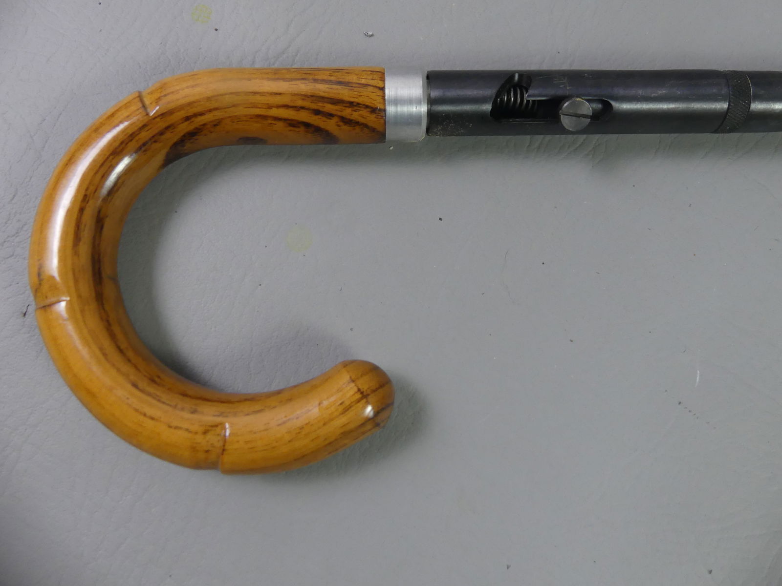 OLD GUN / RIFLE CANE: Old oak gun cane with shepherd hook handle and steel shaft having about a 50 caliber spring-loaded rifle. Barrel is 31 in, overall 35 in.