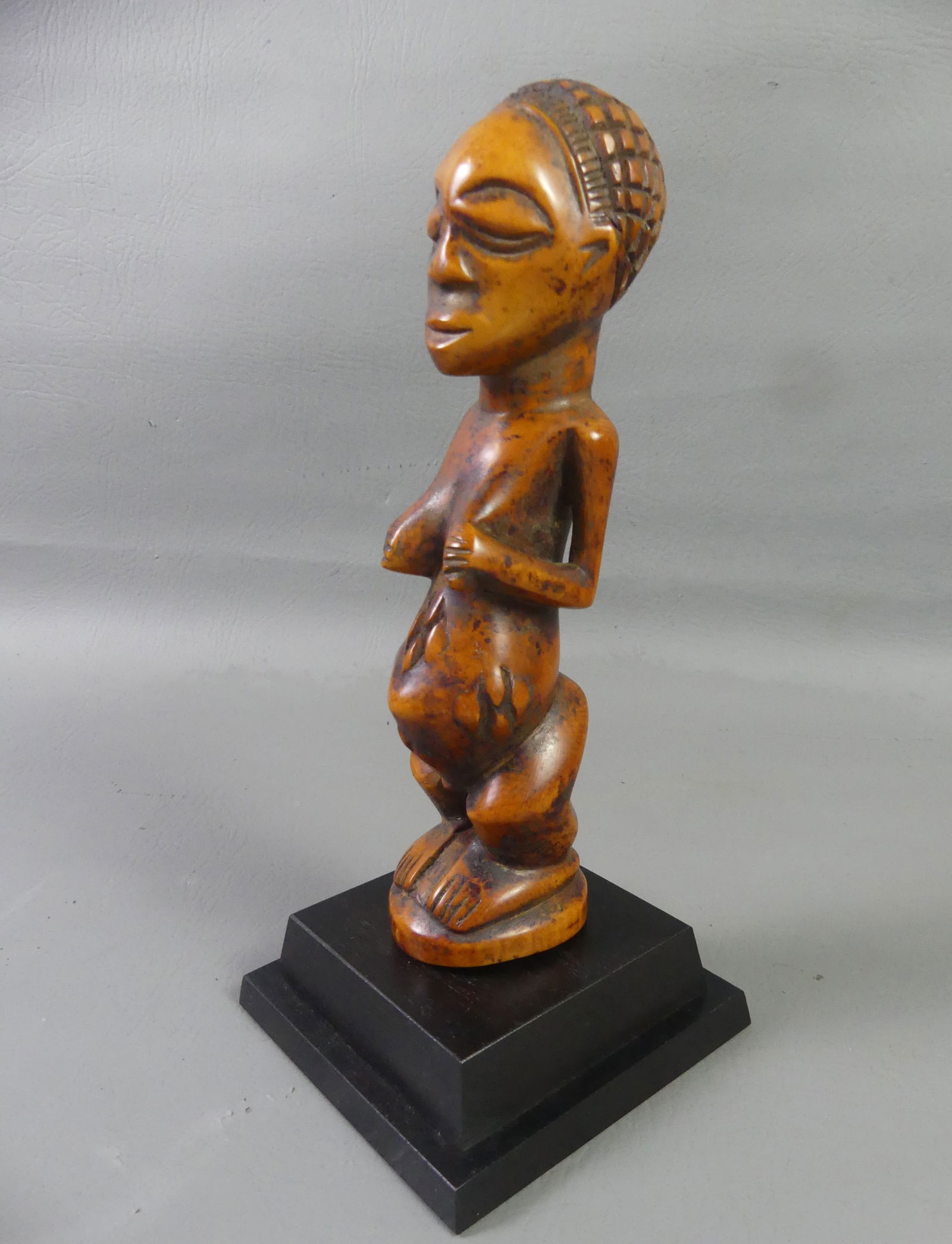 AFRICAN TRIBAL LUBA FETISH: Old carved bone African tribal maternity fetish, on onyx stand. Luba from Zaire/Gabon. Overall 10 in tall.