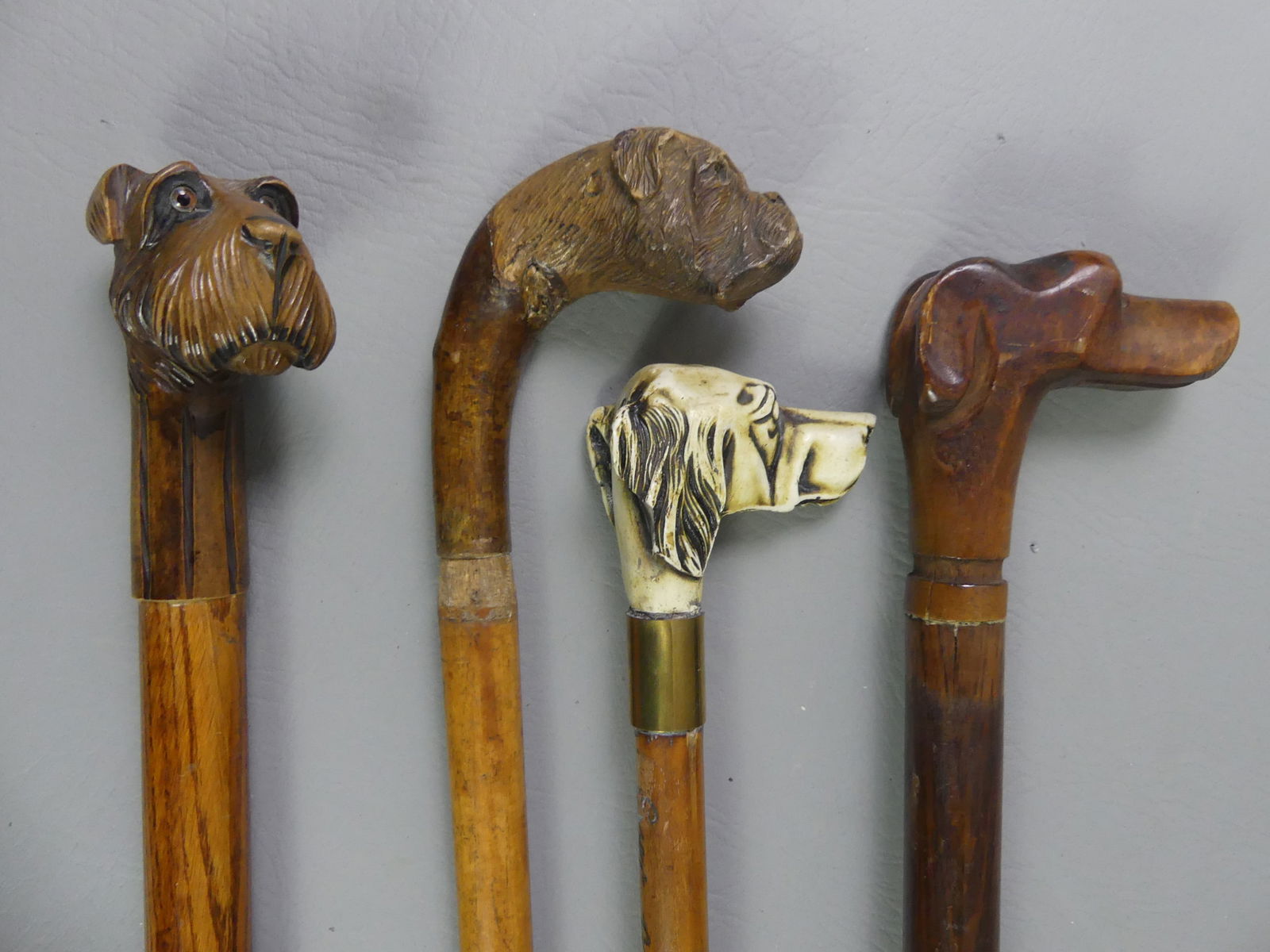 4 DOG HEAD CANES: Lot of 4 old dog head canes / walking sticks to 38 in long: Bulldog head (missing eyes); White composition hound with engraved shaft --True and Noble Companion, Ever at My Side; A Schnauzer dog (shaft
