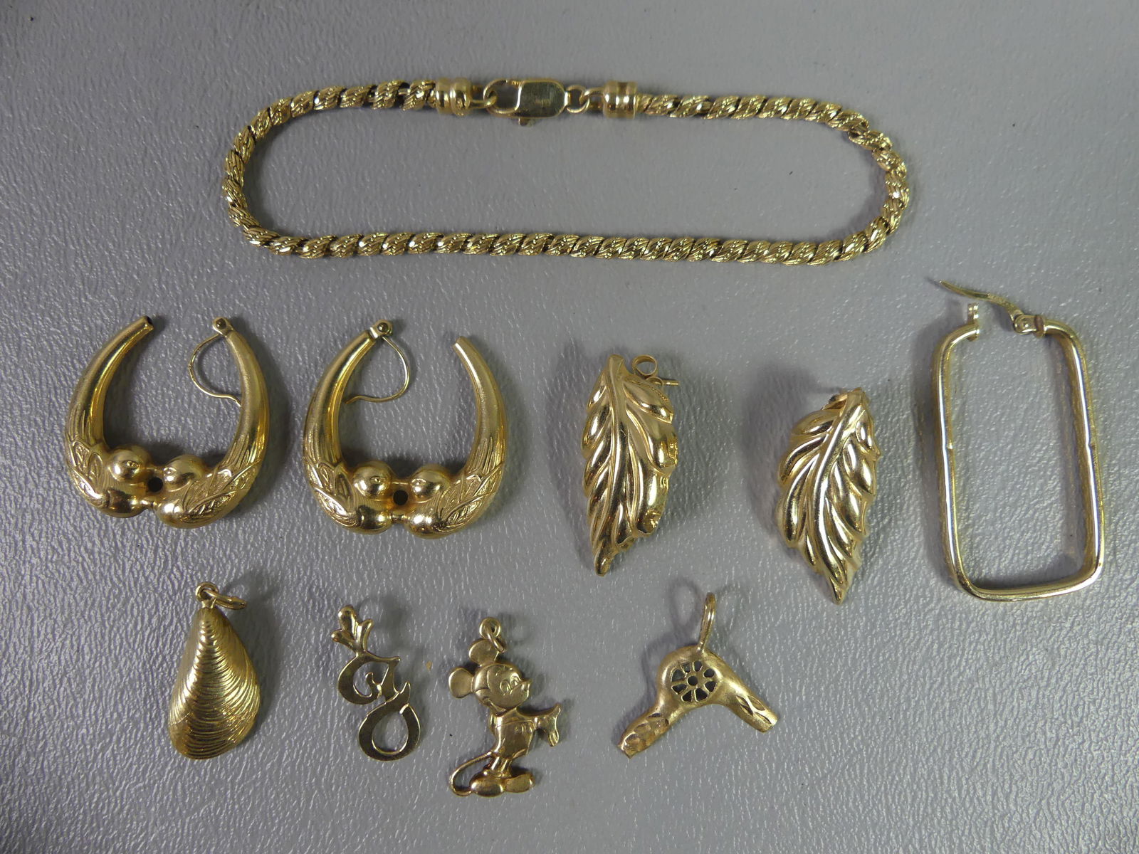 LOT OF 14K GOLD JEWELRY: Lot assorted 14k gold jewelry: 7 inch rope bracelet, 2 pairs of earrings; 4 small pendants; single earring. Total 11.6 dwt. NOTE: We can ship this item in-house