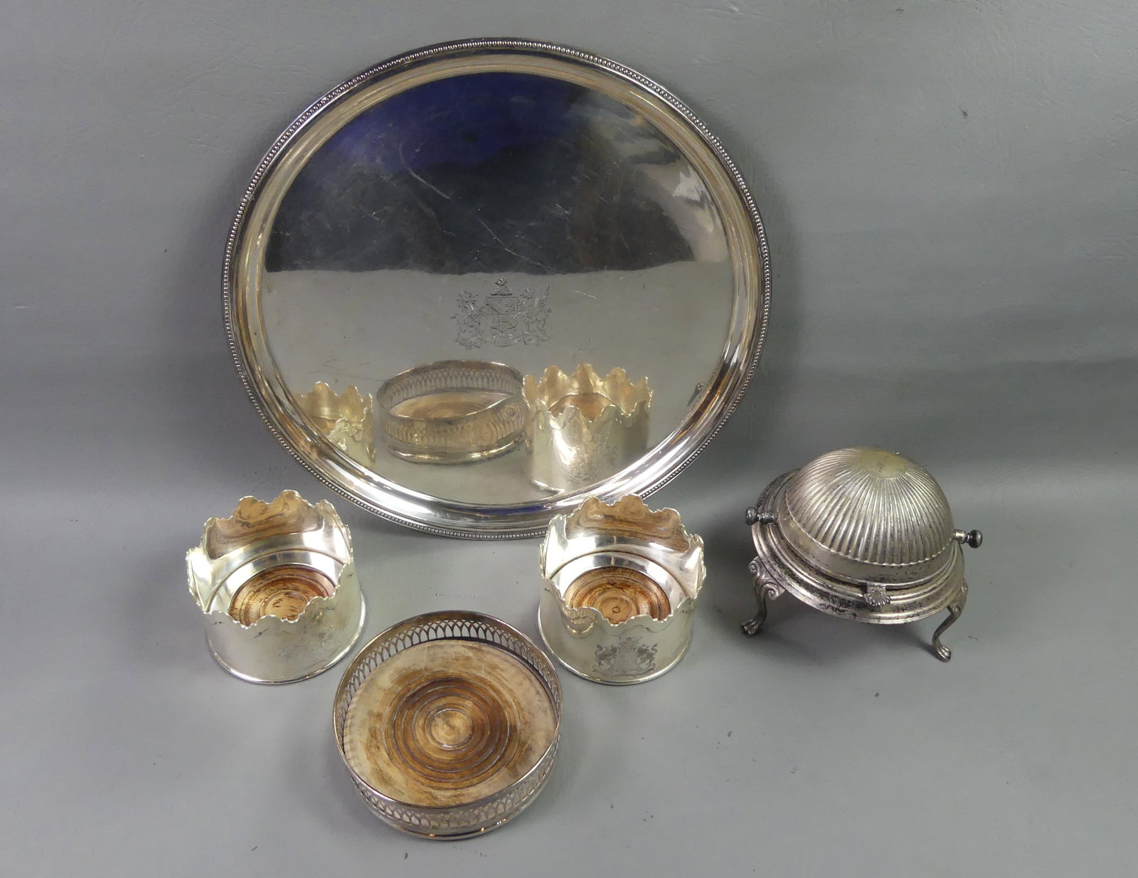 5 ANTIQUE SILVER PLATED ITEMS: Lot 5 antique silver plated items: Pair fine bottle coasters with crowned rim and coat of arms, no marks, 3 in tall x 4 in; Single bottle coaster, 5.5 in; 14 in charger or large salver with engraved c