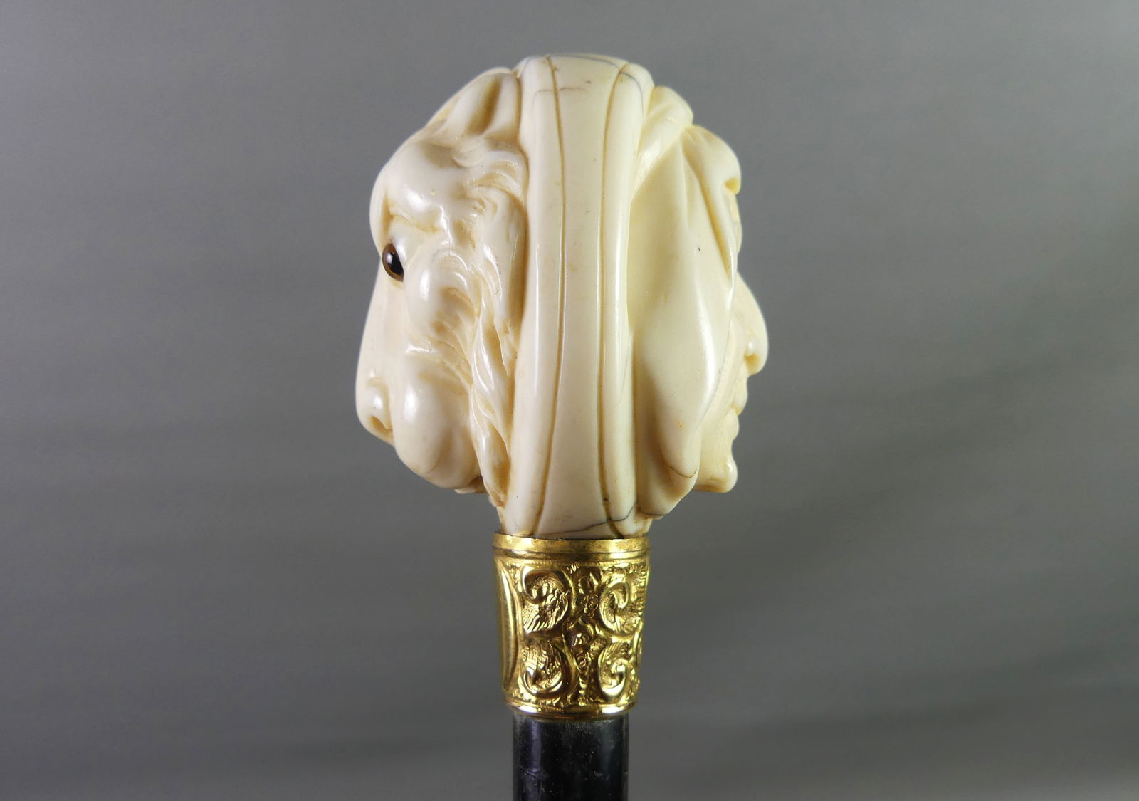 2 FACED BONE CANE -ARAB & LION: 19th century carved bone-handle cane / walking stick with a two-faced knob depicting an Arabic man and a lion with glass eyes. It has a gold-filled collar and ebony shaft. 37 in long, knob is 2 in dia