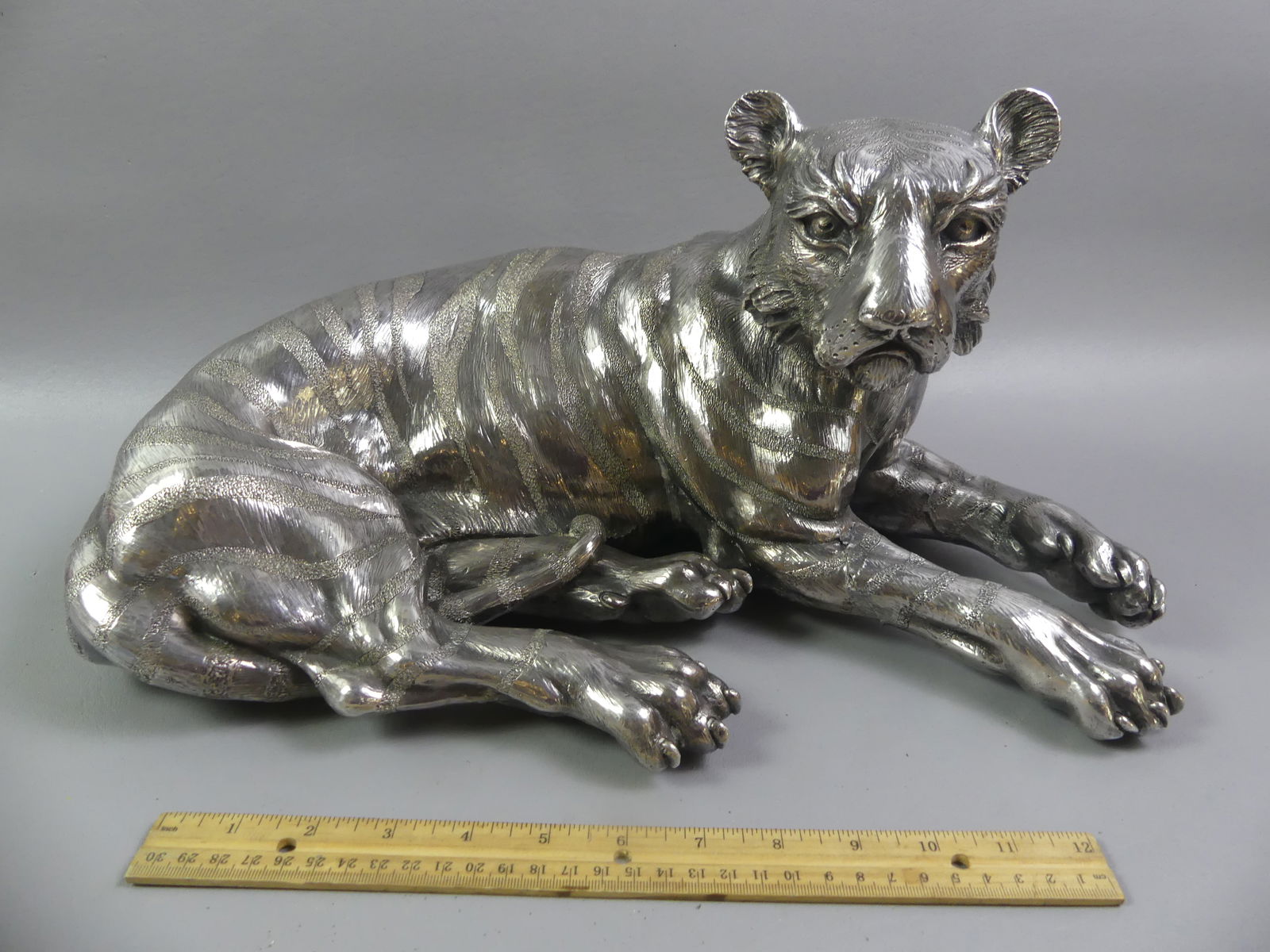 LARGE STERLING OVERLAY TIGER FIGURE: Large sterling silver overlay reclining tiger figure with 925 hallmark and 250 grams of silver. Overall weight 103 oz. Size: 17 in long x 9 x 10 in. Front legs have been repaired.