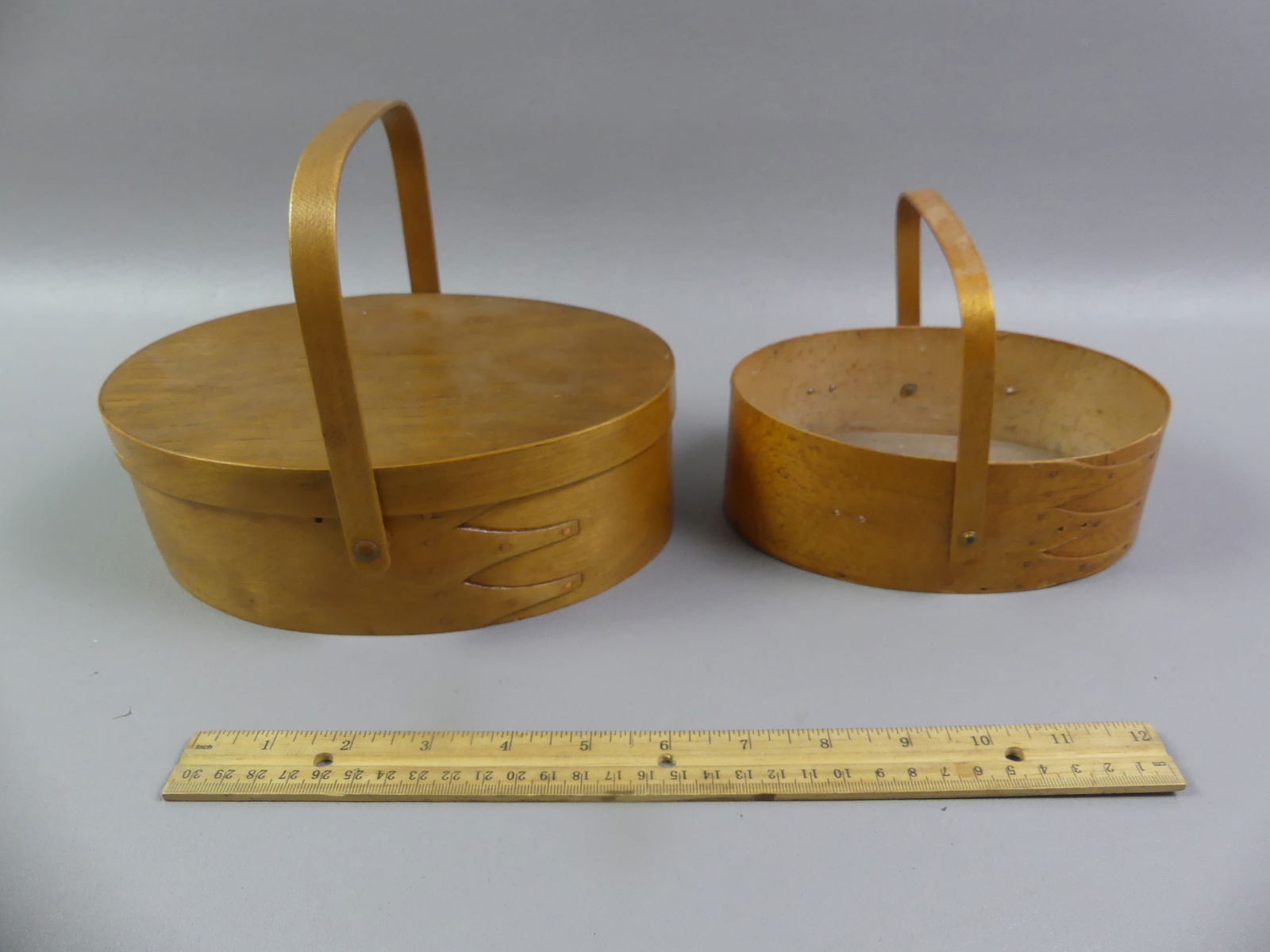 2 SHAKER SEWING BASKETS: Lot of 2 Shaker bentwood sewing baskets with handles: 9 x 3 inch signed Mt. Lebanon NY with finger joints and lid (small loss to edge of cover); and a signed Sabbath Day Lake Maine basket (missing a