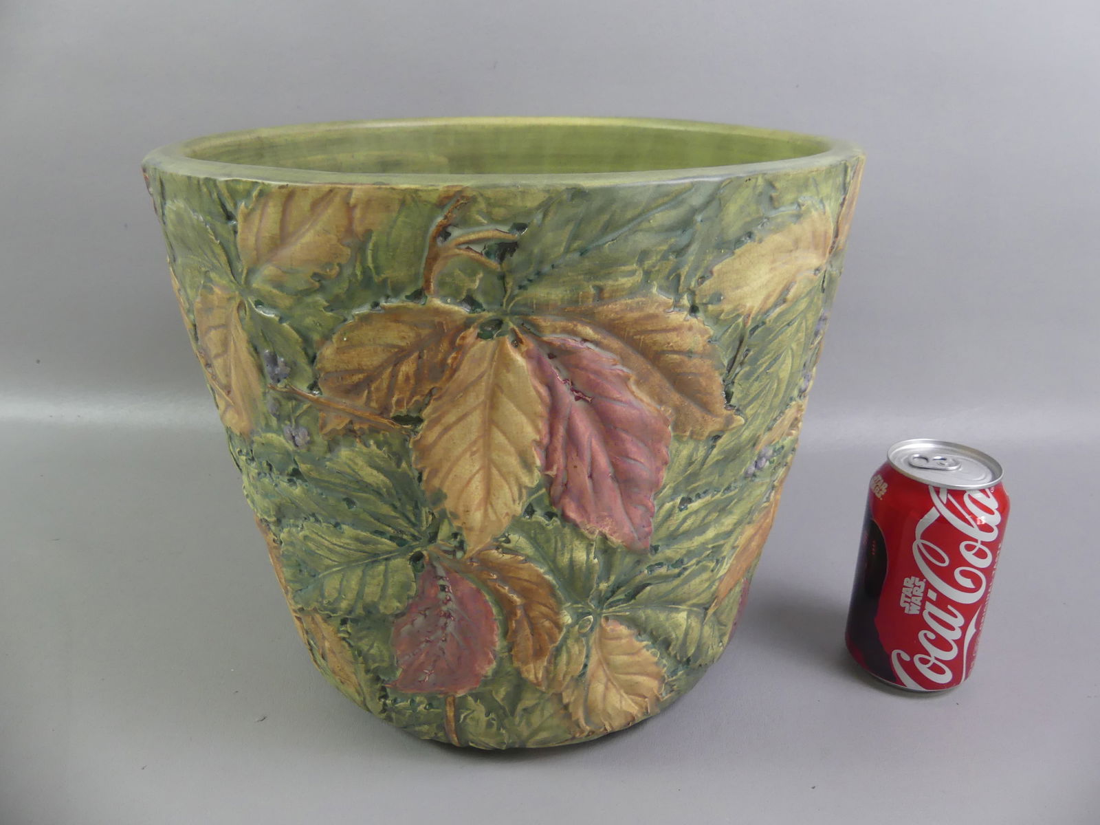 WELLER FLEMISH ART POTTERY JARDINIERE: Large Weller art pottery jardiniere with colorful embossed leaves and berries in the Flemish design. 10.75 in tall, 12.5 in diameter. VG condition.NOTE: We can ship this item in-house.