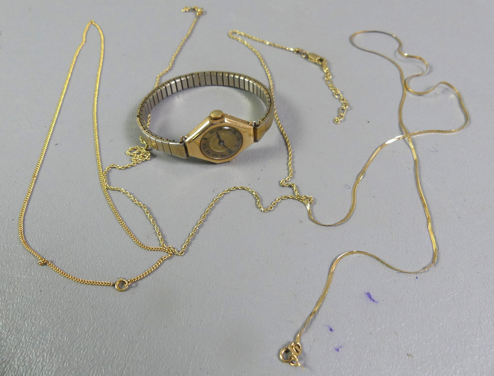 LECOULTRE 14K GOLD WATCH & CHAINS: Lot of 14k gold: LeCoultre ladies wristwatch with stamped 14k gold watch case (not band); 3 broken 14k gold thin chains. Chains are 5 dwt, watch weighs 13.6 including movement and band that is not