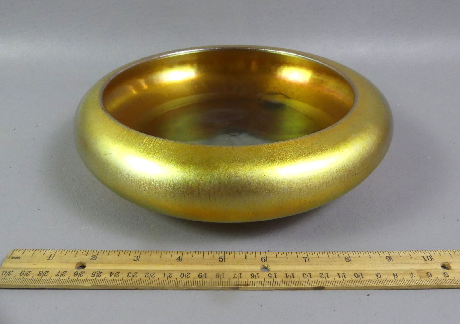 STEUBEN AURENE ART GLASS BOWL: Art Nouveau period gold art glass footed bowl by Steuben signed AURENE - 2580. 10 in diameter and 2.25 in high. Good condition with some wear on interior.