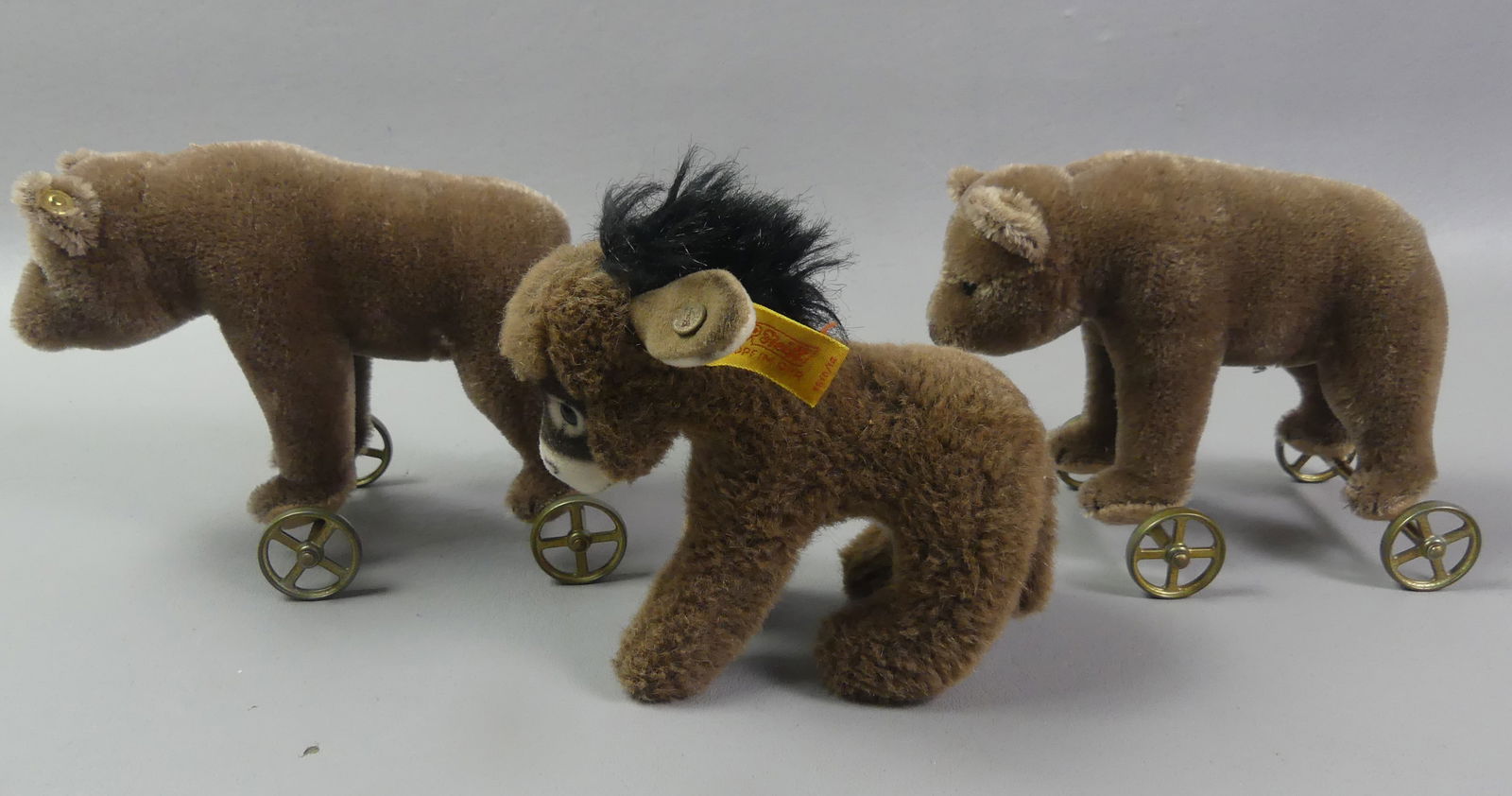 3 STIEFF ANIMALS: Lot of 3 vintage Stieff stuffed animals: Pair of mohair bear pull toys on wheels, 5 x 6.5 in long; and 5 in donkey. All have button-in-ear tags. VG condition. NOTE: We can ship this item in-house.