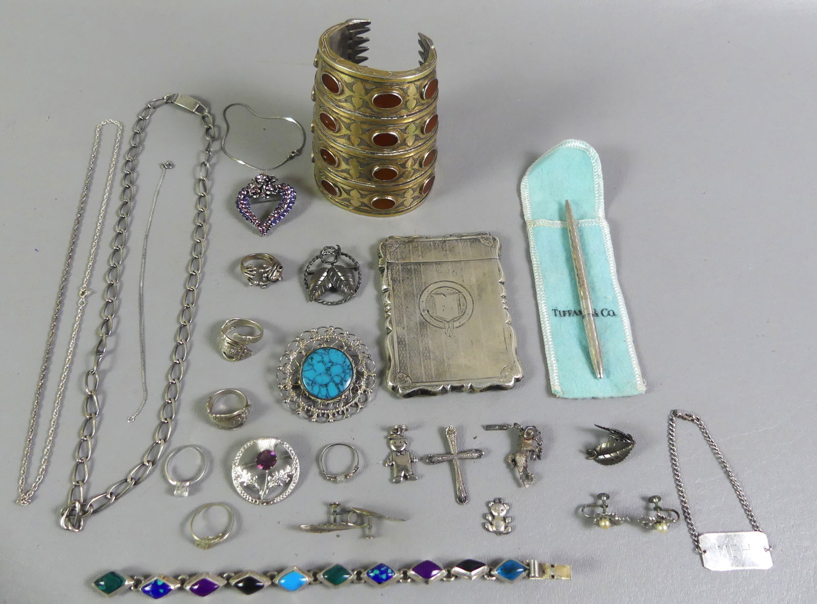 LOT SILVER ITEMS & TIFFANY PEN: Assorted group of sterling silver: Tiffany & Co. pen; 4 in heavy cuff bracelt with inset oval stones, 8.6 ozt; 3.25 in engraved card case; necklaces, rings, pendants, etc. Total 15.76 ozt. NOTE: We