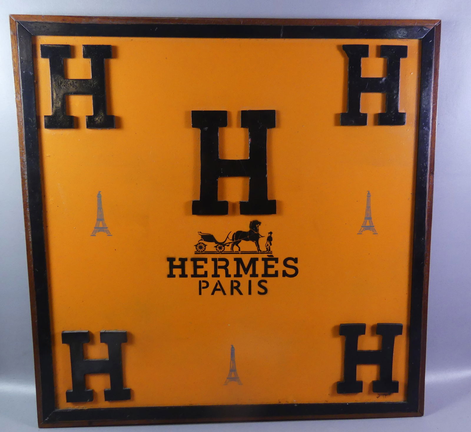 HERMES ADVERTISING WALL PICTURE: Vintage Hermes framed advertising picture with 5 wooden H's mounted on painted orange canvas with stenciled Eiffel Towers, horse drawn carriage and HERMES PARIS. Signed J. Diamond in lower right