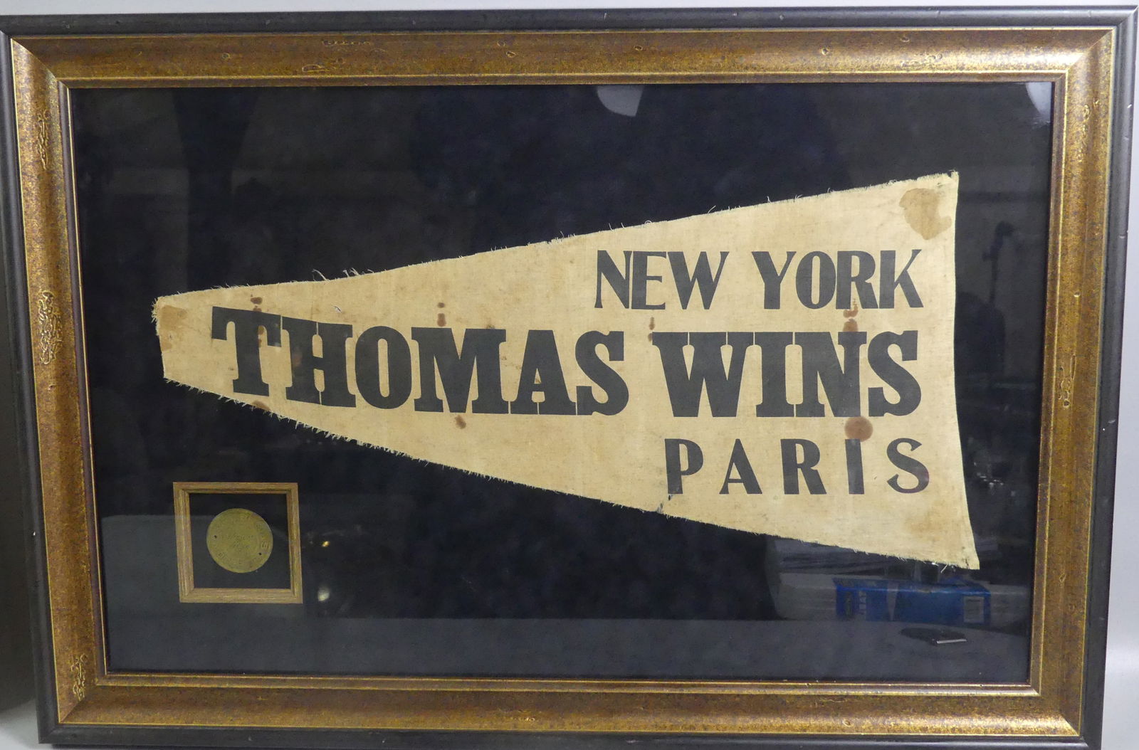 THOMAS MOTOR CO. PENNANT & MEDAL: Rare framed pennant and brass medallion for the Thomas Motor Co. circa 1908. Pennant states -- New York Thomas Wins Paris -- with 2 in medallion embossed --E.R. Thomas Motor Co. Thomas Flyer. Pennant