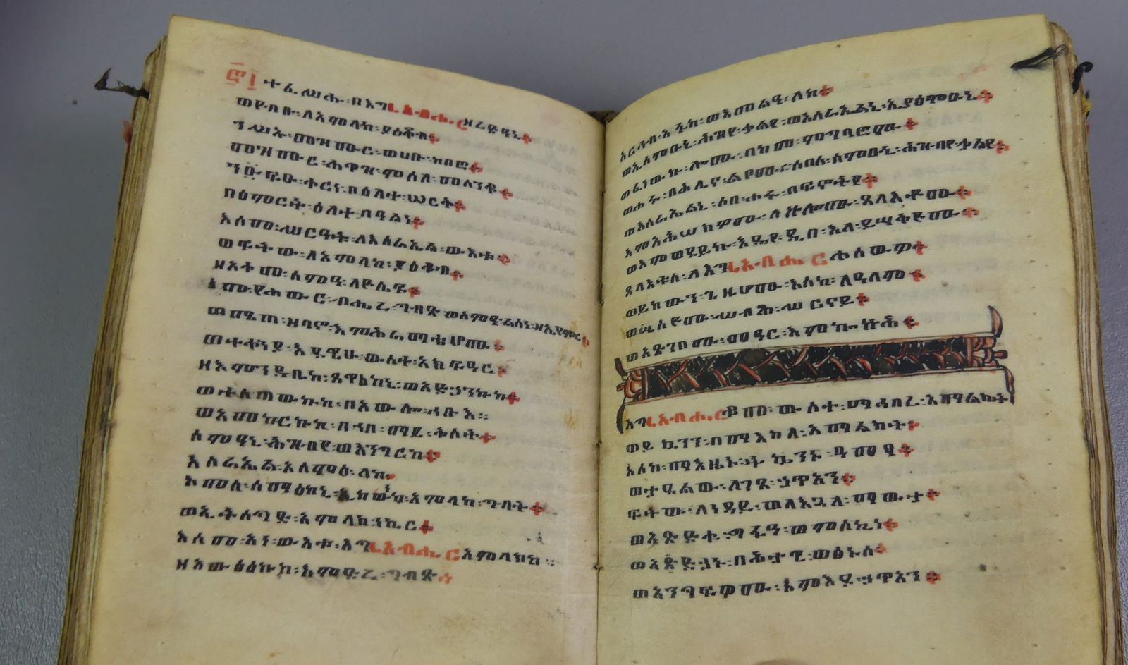 EARLY AMHARIC BIBLE & DICTIONARY: 18th century (or earlier) Amharic hand illuminated bible or prayer book on vellum, mounted in hand made suede pouch. Comes with an 1841 Dictionary of Amharic Language by Rev. Charles Isenberg of the