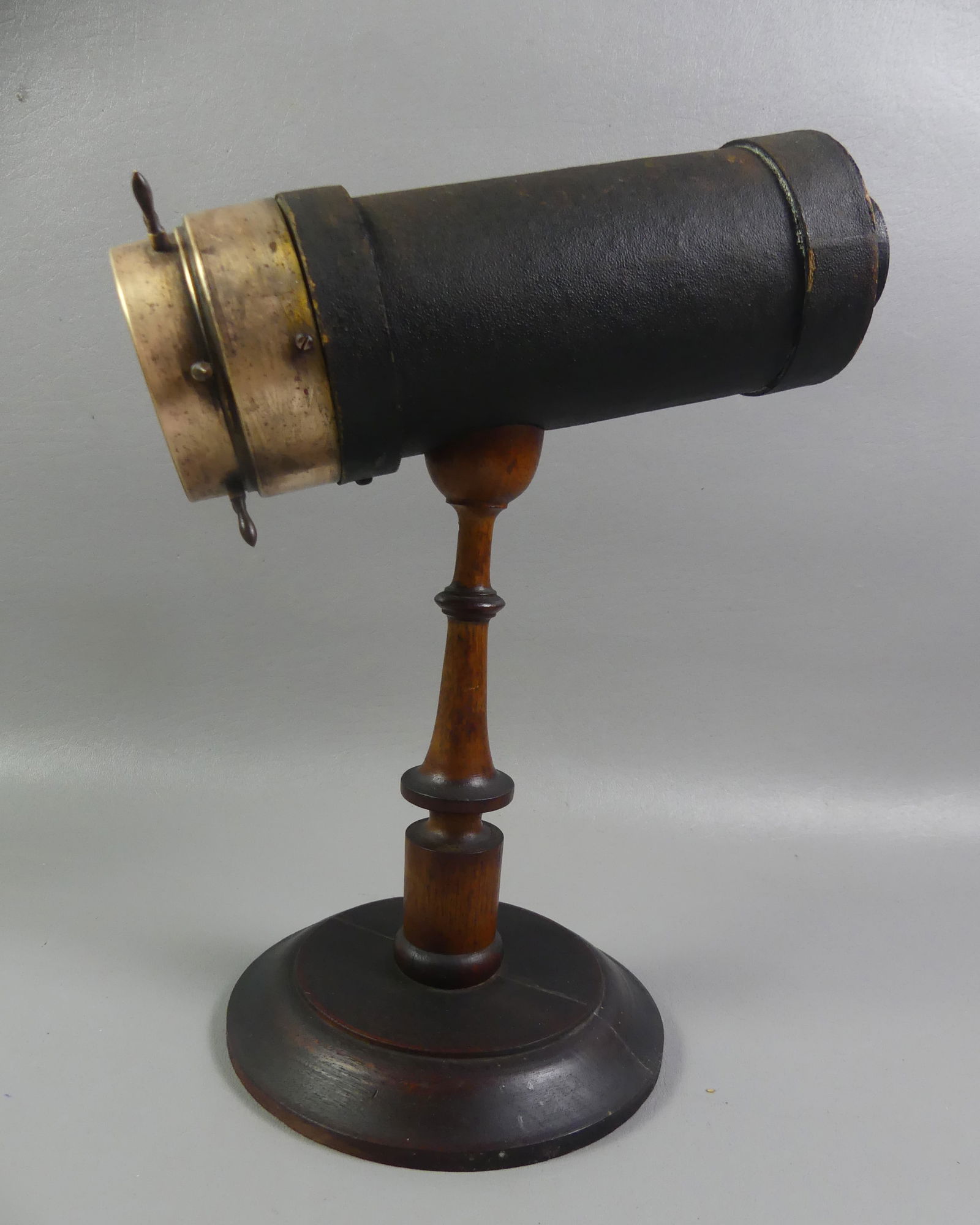 VICTORIAN WOOD & BRASS KALEIDOSCOPE: 19th century wood and brass kaleidoscope attr. Charles Bush. It has a ship's wheel style revolving end with colorful glass pieces inside that make geometric designs. 14 in tall x 10 in long. NOTE: We