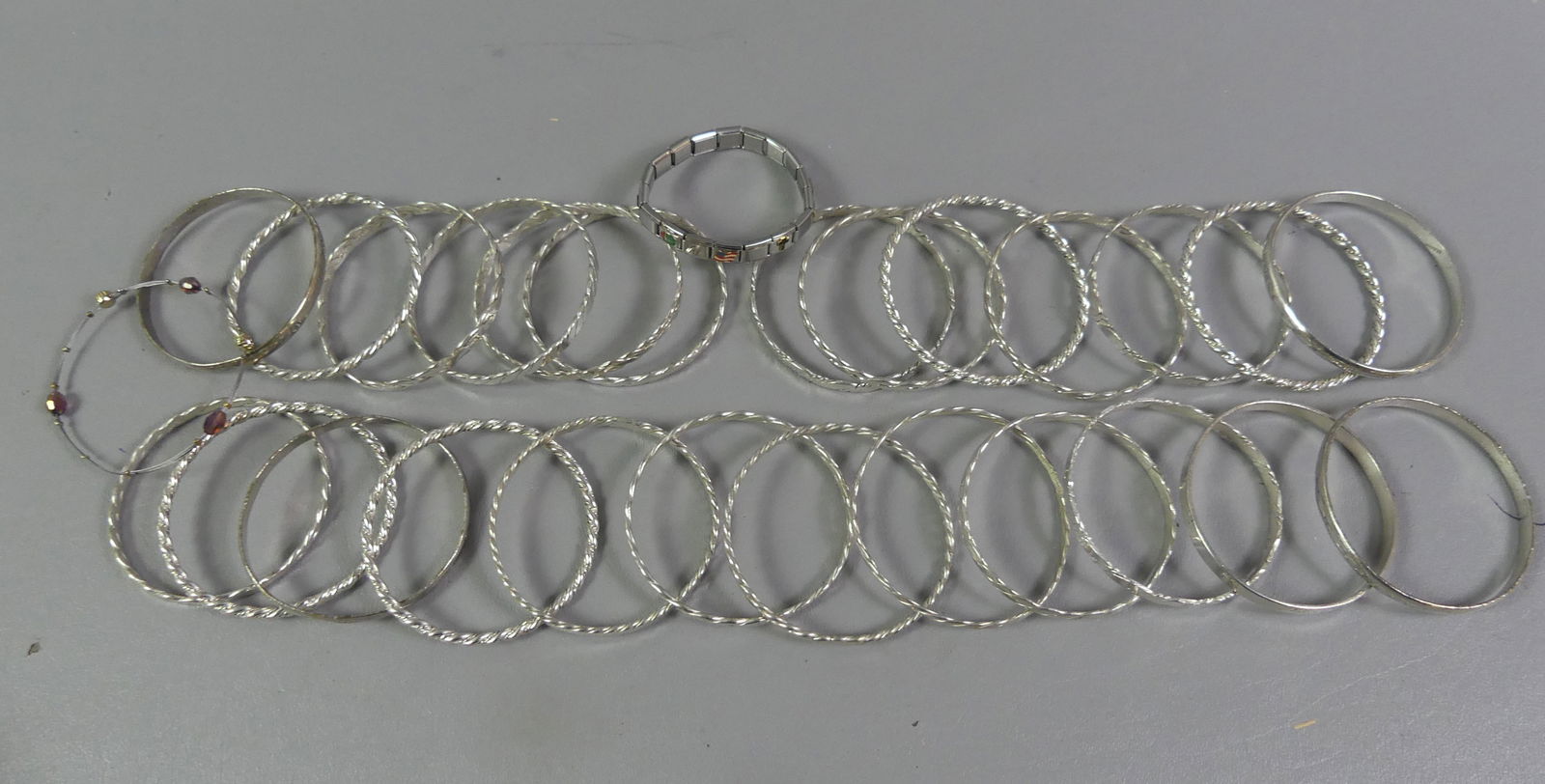 27 STERLING SILVER BRACELETS: Group of 27 assorted sterling silver bracelets, most bangle style, one stainless steel CHICKIE. Total weight not including 2 bracelets that are not sterling 13.17 ozt. NOTE: We can ship this item