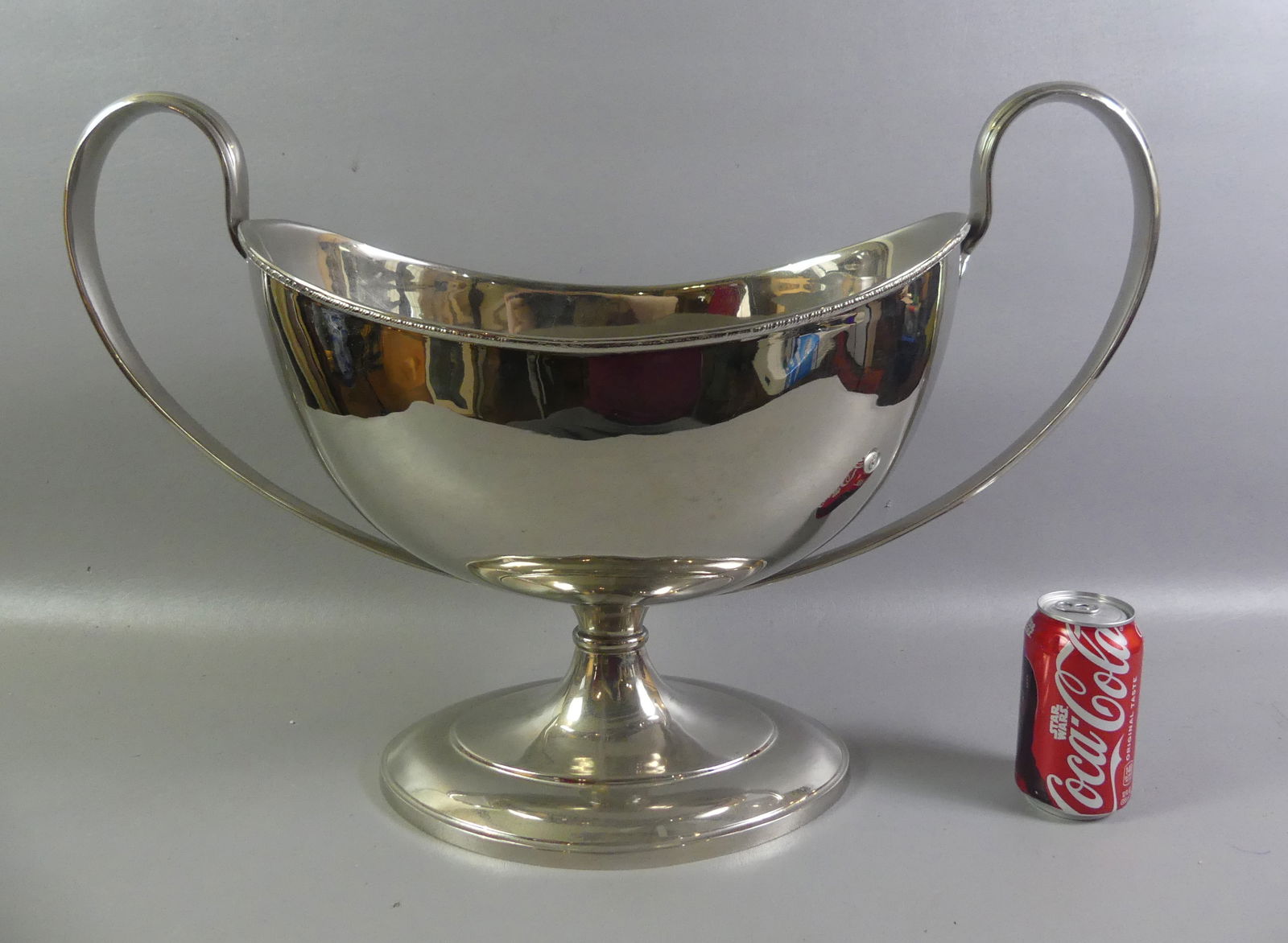 HUGE SILVERED CENTERPIECE URN: Very large silver plated, two-handled centerpiece urn. No hallmarks, probably mid-20th century. 24.5 in wide and 16.5 in hgh. VG condition. NOTE: We can ship this item in-house.