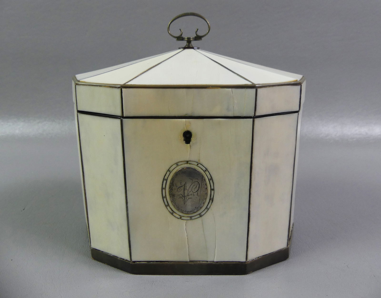 REGENCY PERIOD SILVER MOUNTED DOUBLE TEA CADDY: Fine Regency period 10-sided double tea caddy with bone paneled veneer exterior and sterling silver mounts. It has two interior covers (loose) and silver medallion on exterior with monogram. Interior
