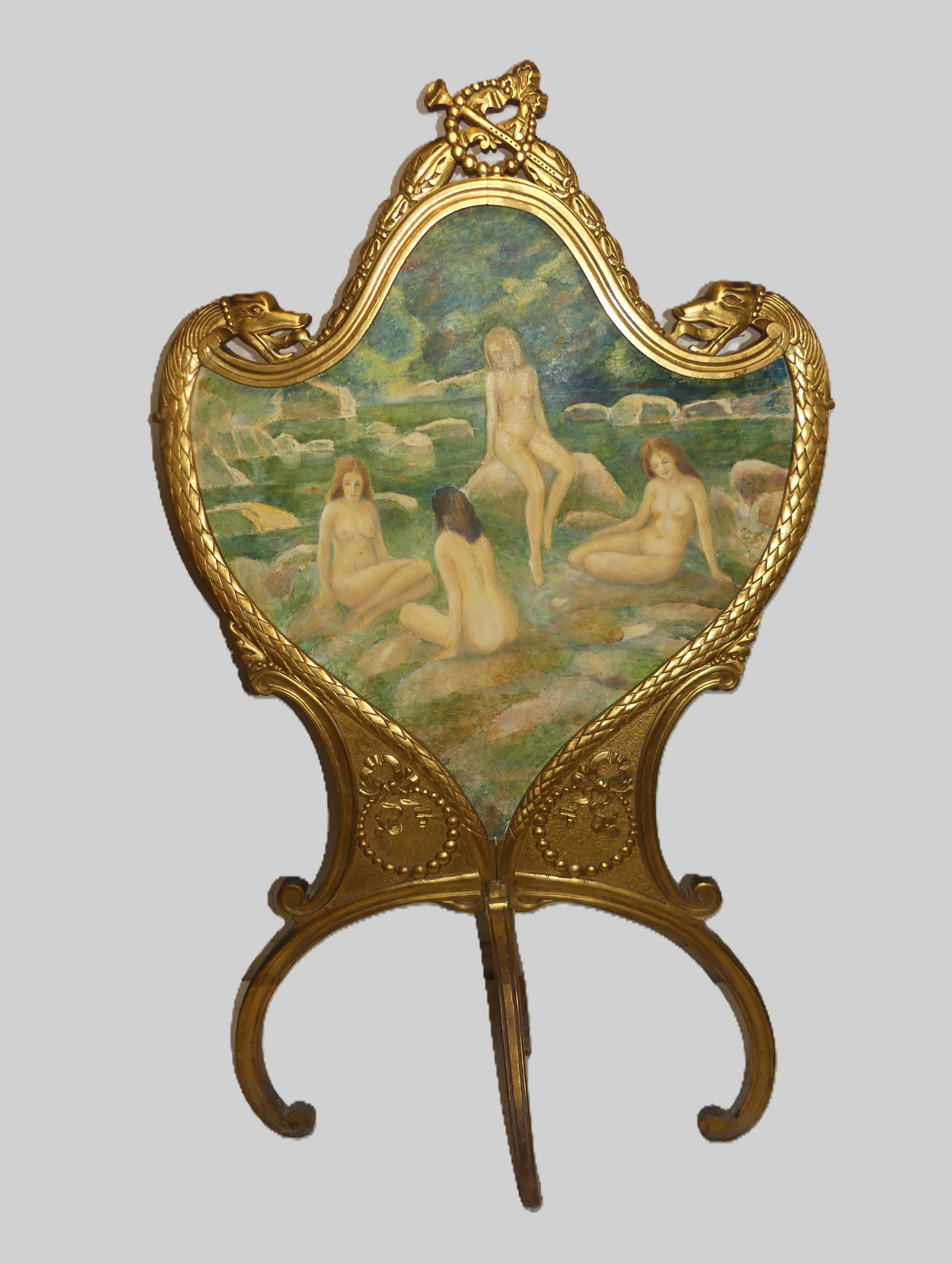 GILT WOOD FRENCH PAINTED FIRESCREEN - NUDES: Old giltwood carved French firescreen with shield-shape center painting on canvas of 4 nude women bathing. Signed indistincly in lower right. 53 in high x 30 in, splayed legs 14 in wide. Early /mid