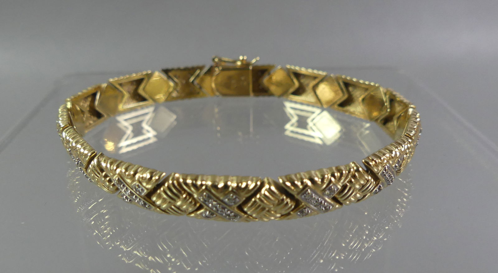 14K GOLD BRACELET WITH DIAMONDS: 14k gold fancy bracelet with X design and tiny diamonds, 1/4 inch wide and 7.25 in long. Weighs 9.3 dwt. NOTE: We can ship this item in-house.