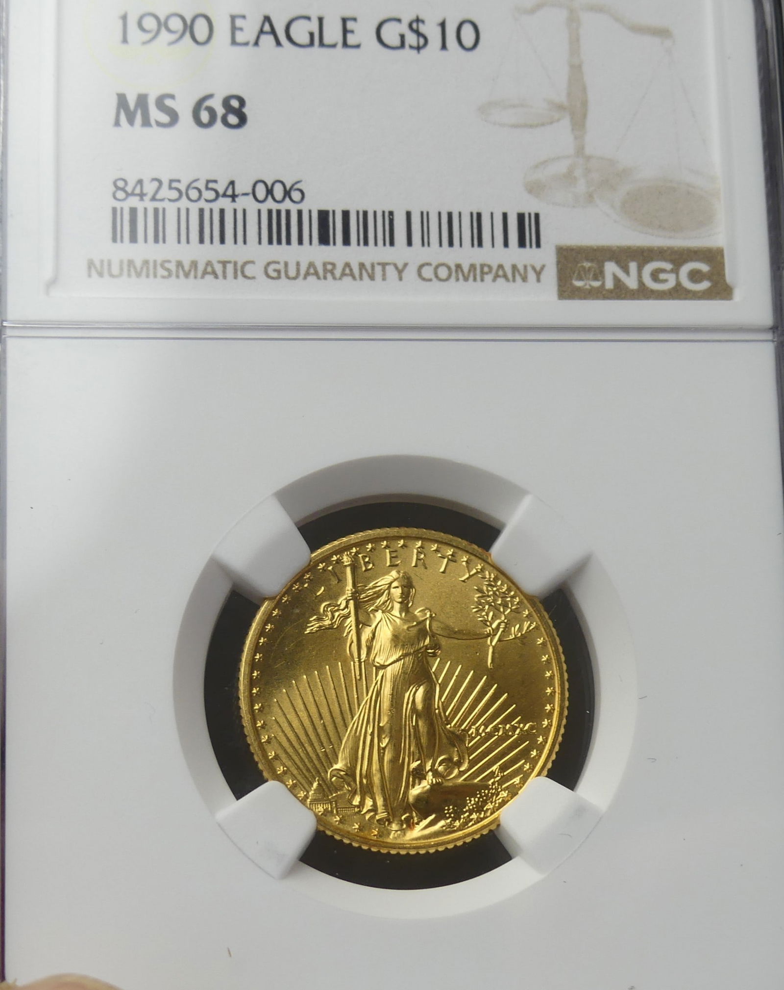 1990 GOLD EAGLE $10 COIN: 1990 Gold Eagle $10 coin (slabbed) with NGC grade of MS68. Content: 1/4 oz .999 gold.