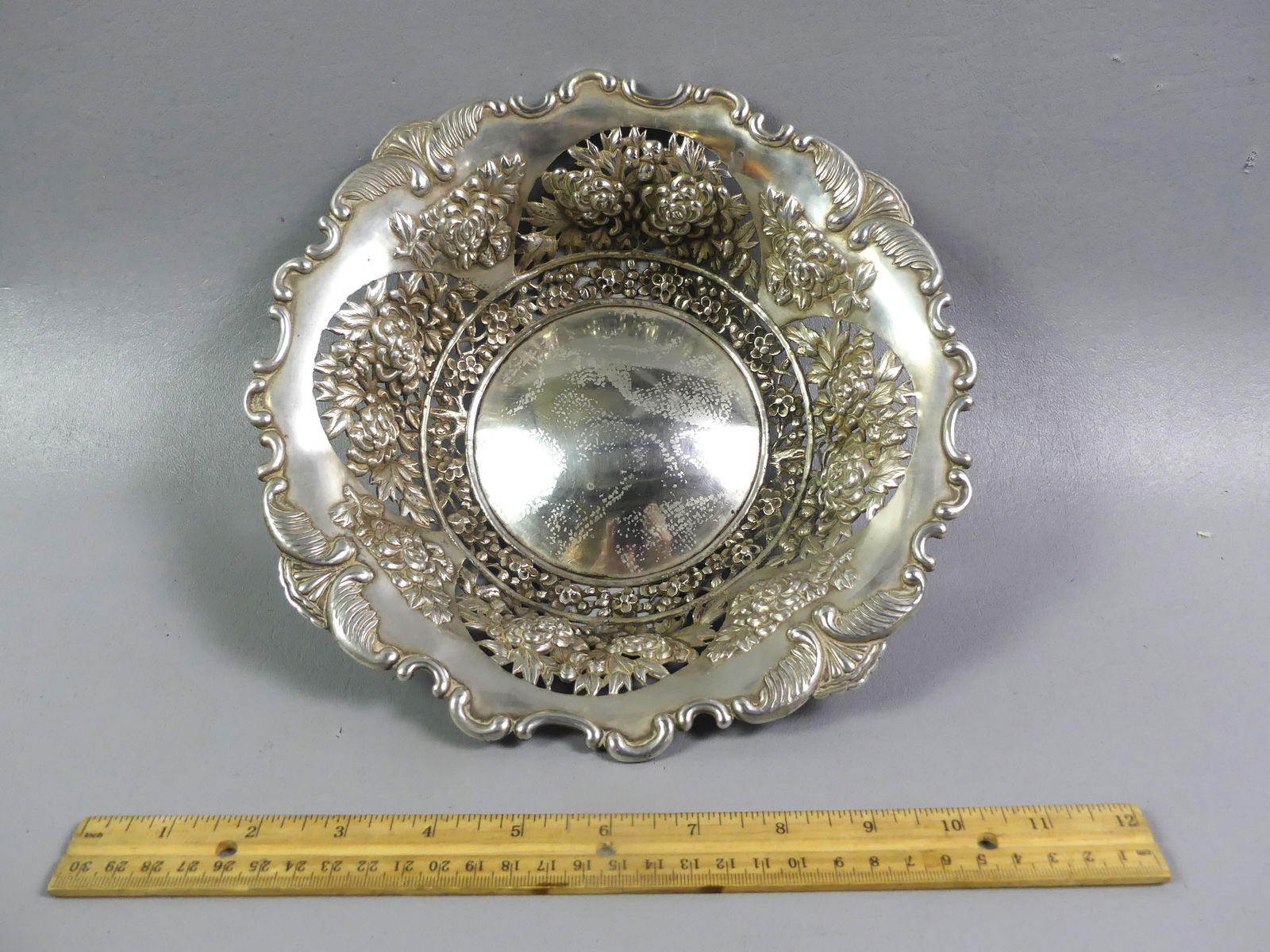 CHINESE SILVER BOWL SIGNED LUEN-WO: Wonderful antique Chinese silver reticulated fruit bowl with chrysanthemum designs, shaped rim. Stamped on back with Asian characters and SHANGHAI / LUEN-WO. 10 in diameter by 2.25 in deep, weighs