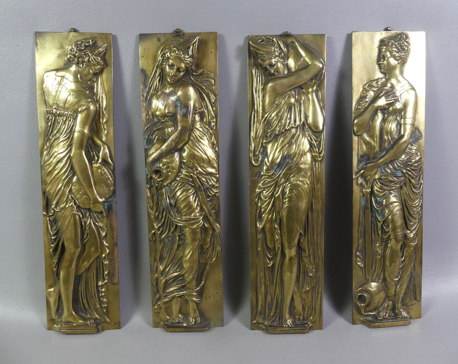 SET 4 BRONZE CLASSICAL PLAQUES: Set of 4 Victorian gilt bronze wall plaques with classical female figures. Stamped EA in lower corner. 17 in high x 4.5 in wide. Some scattered light oxidation/staining. NOTE: We can ship this item in