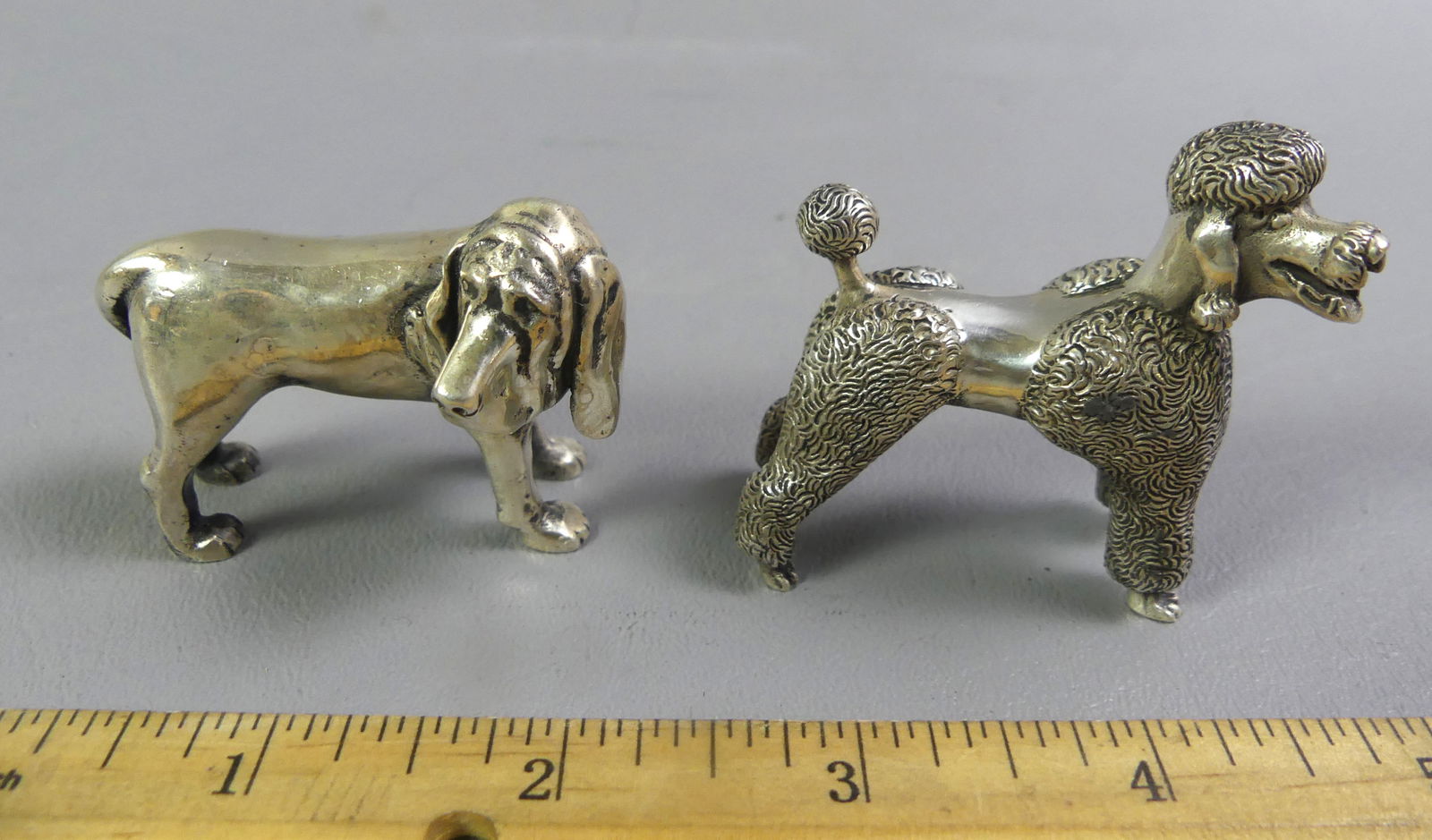 2 KIRK STERLING MINI DOG FIGURINES: 2 vintage S. Kirk & Son miniature sterling silver dog figurines from the ANIMAL SPIRITS collection. A Bloodhound #1548, 2 x 1.75 in; and a poodle #1549. Total weight 7.8 ozt. They are 1.75 x 1 in in