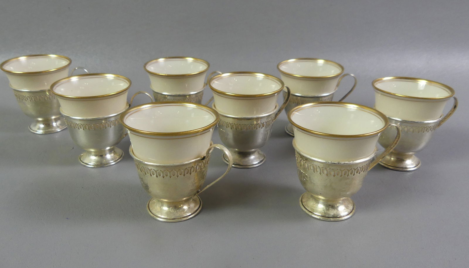 8 LENOX & STERLING SILVER CUPS: Set of 8 reticulated sterling silver demitasse cup holders with Lenox porcelain inserts (green mark). 2.5 in high, silver weighs 5.5 ozt. All good condition. NOTE: We can ship this item in-house.