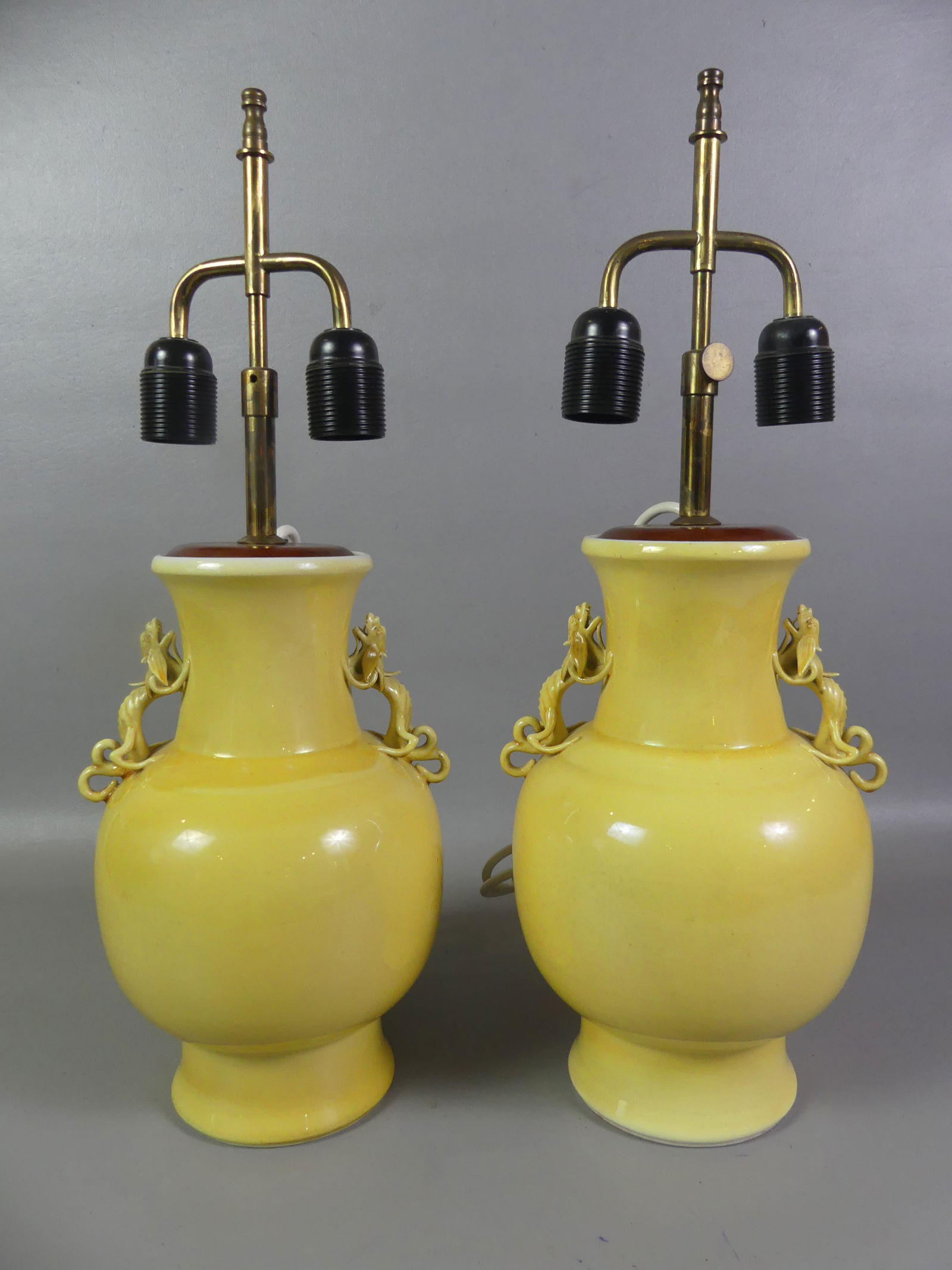 PAIR FAMILLE JAUNE CHINESE LAMPS: Pair of old Chinese yellow-glazed vases mounted as lamps with dragon handles, signed with blue seal on underside. They have been properly electrified at top with a European cord and plug. Vases are