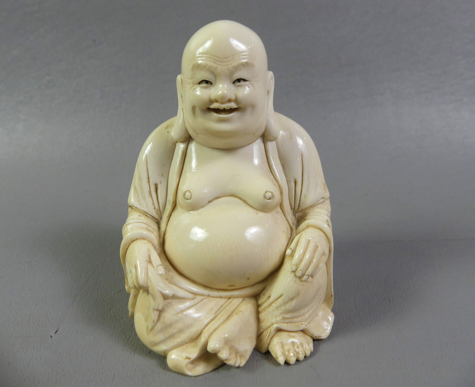 CHINESE SEATED BUDDHA CARVING: Antique Chinese carved bone figure of a seated buddha. Signed on base. 3.75 x 2.75 x 2.25 inches. NOTE: We can ship this item in-house.