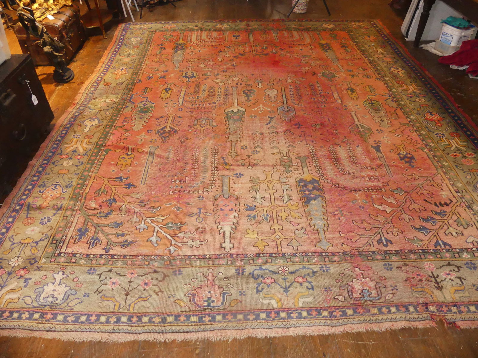 ROOM SIZE ANTIQUE TURKISH OUSHAK RUG: Antique red Turkish Oushak room size carpet with allover trees design. Has wear/couple holes. 10 ft 10 x 13 ft 6 inches. Sold as is. NOTE: We can ship this item in-house.