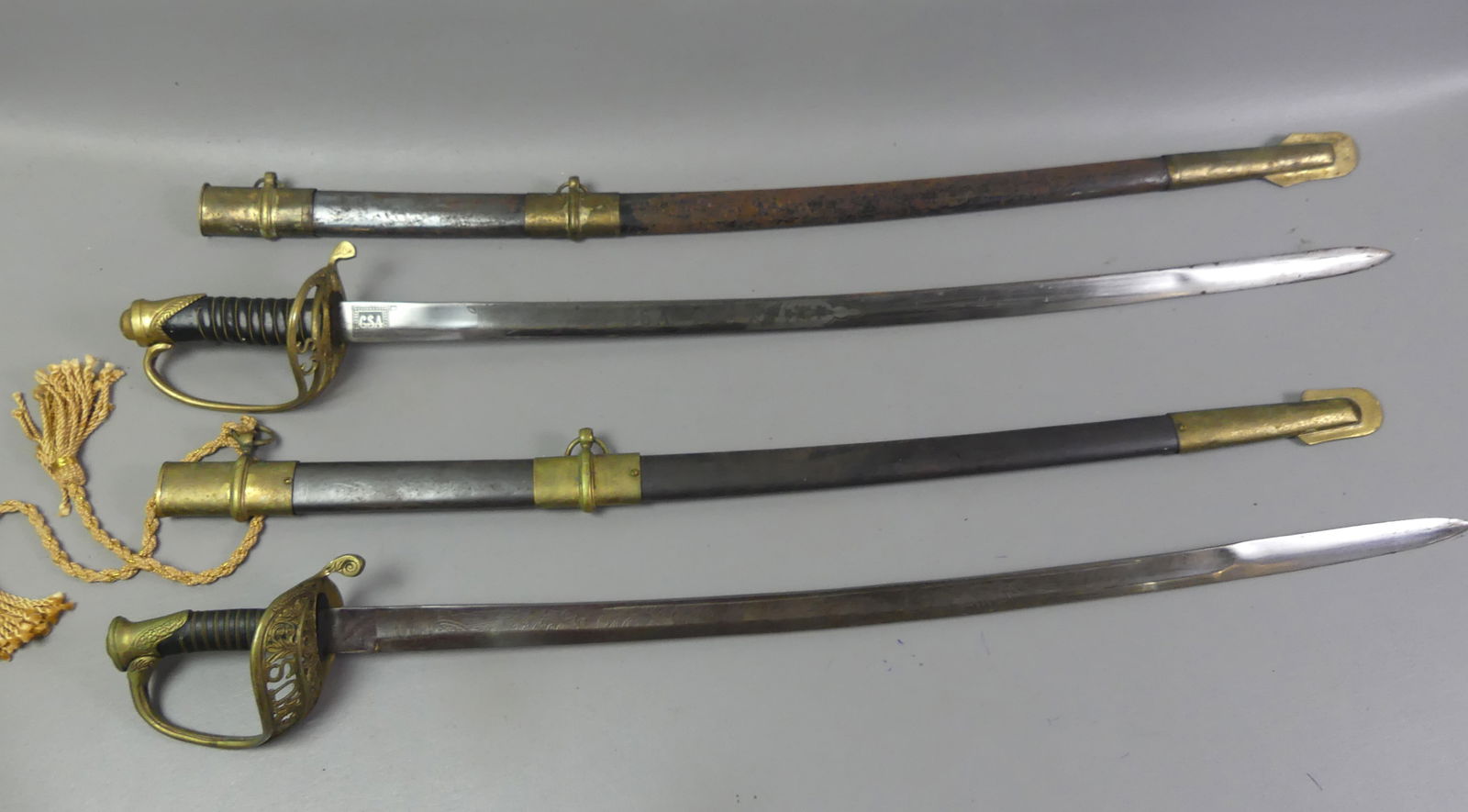 CIVIL WAR REPRO. SWORDS - US & CSA: Two vintage reproduction Civil War swords, both with engraved blades and metal scabbards. Confederate States of America, 38.5 in long, and Federal sword, 36 in long. Good condition, the CSA scabbard