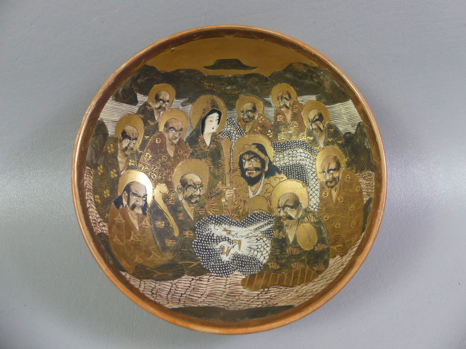 JAPANESE MEIJI BOWL - THOUSAND FACES: Fine Japanese Meiji period art pottery bowl with Thousand Faces design and dragon. Signed on underside with orb mark and characters. 7.25 x 3 in high. VG condition.