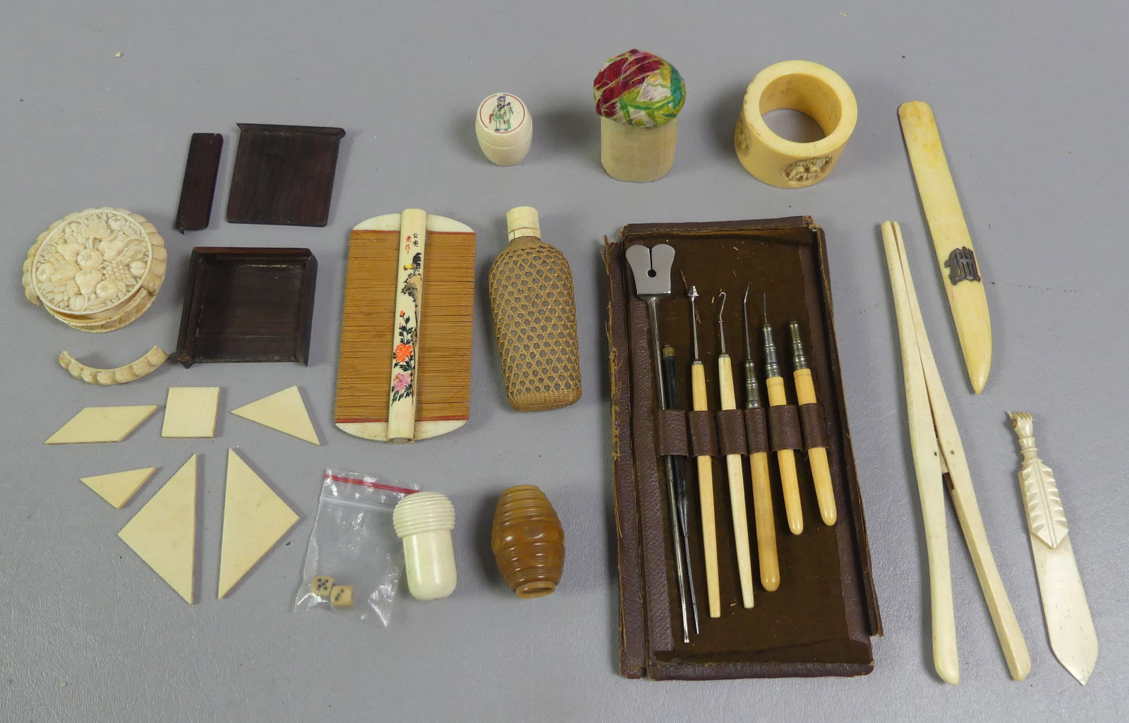 MOSTLY JAPANESE CARVED BONE ITEMS: Lot of Asian carved bone items: lice comb, signed; 3 thimble containers; napkin ring; letter openers; set of picks; 3 in flask; pin cushion; round carved floral mini box (as is); and mini wood puzzle