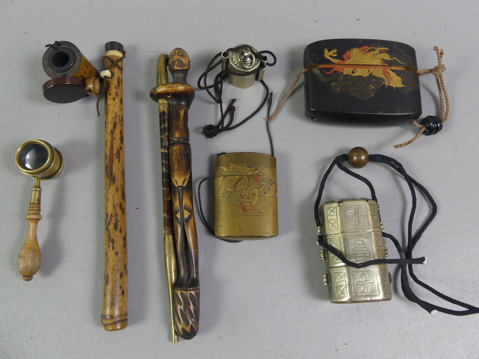 7 OLD JAPANESE ITEMS & INROS: Group of 7 Asian items including 9 in figural pipe; pen holder and ink pot; 3 stacking Japanese inro containers in metal and lacquered wood; brass magnifier (not Asian). NOTE: We can ship this item in