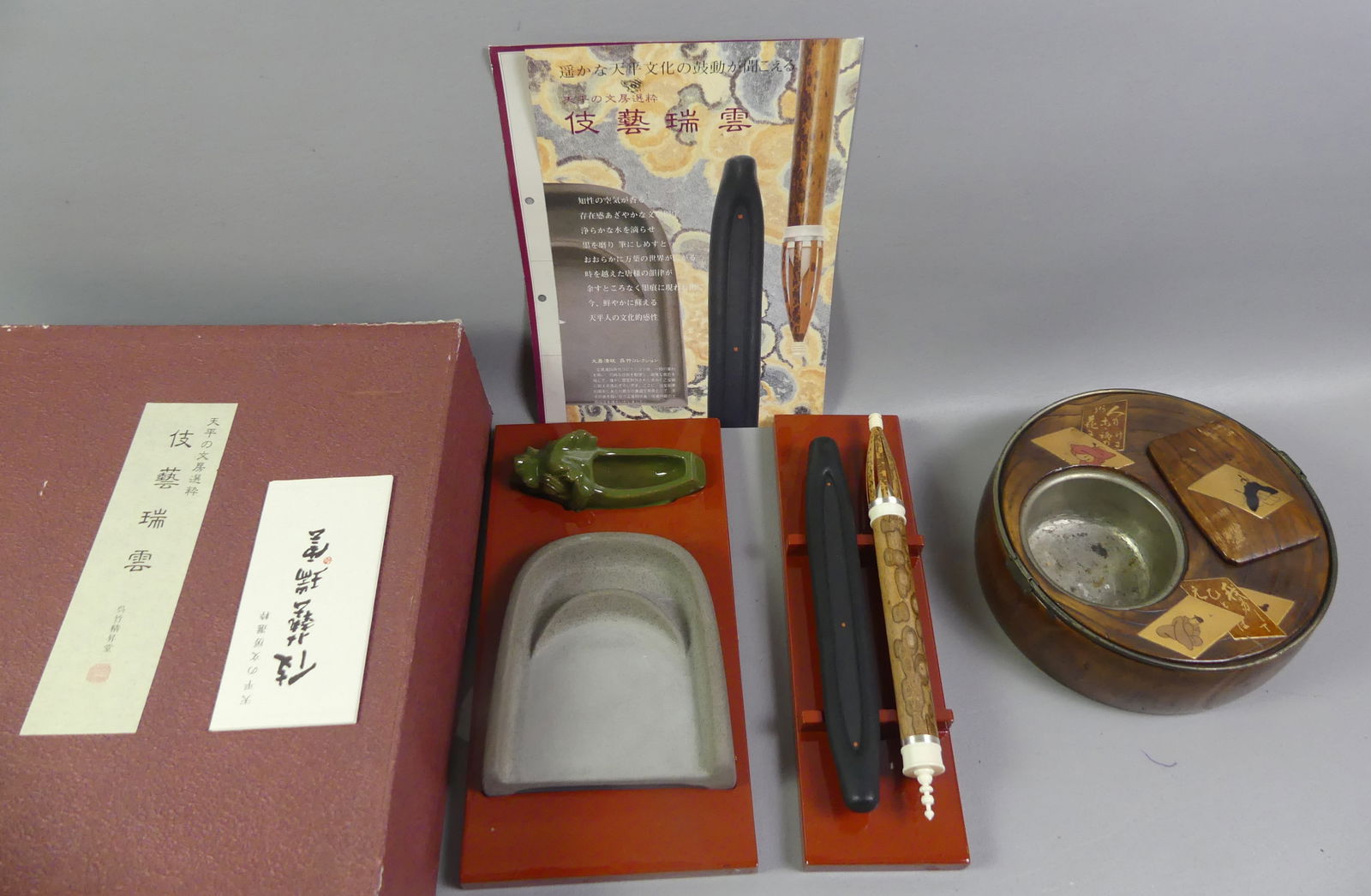 JAPANESE CALLIGRAPHY SET & HIBACHI: 2 fine quality Japanese items: Meiji period lacquered Paulownia wood round hibachi with brass handles and plaque with poetry, 8 in diam and 3 in high; and a Japanese calligraphy set with ceramic trays