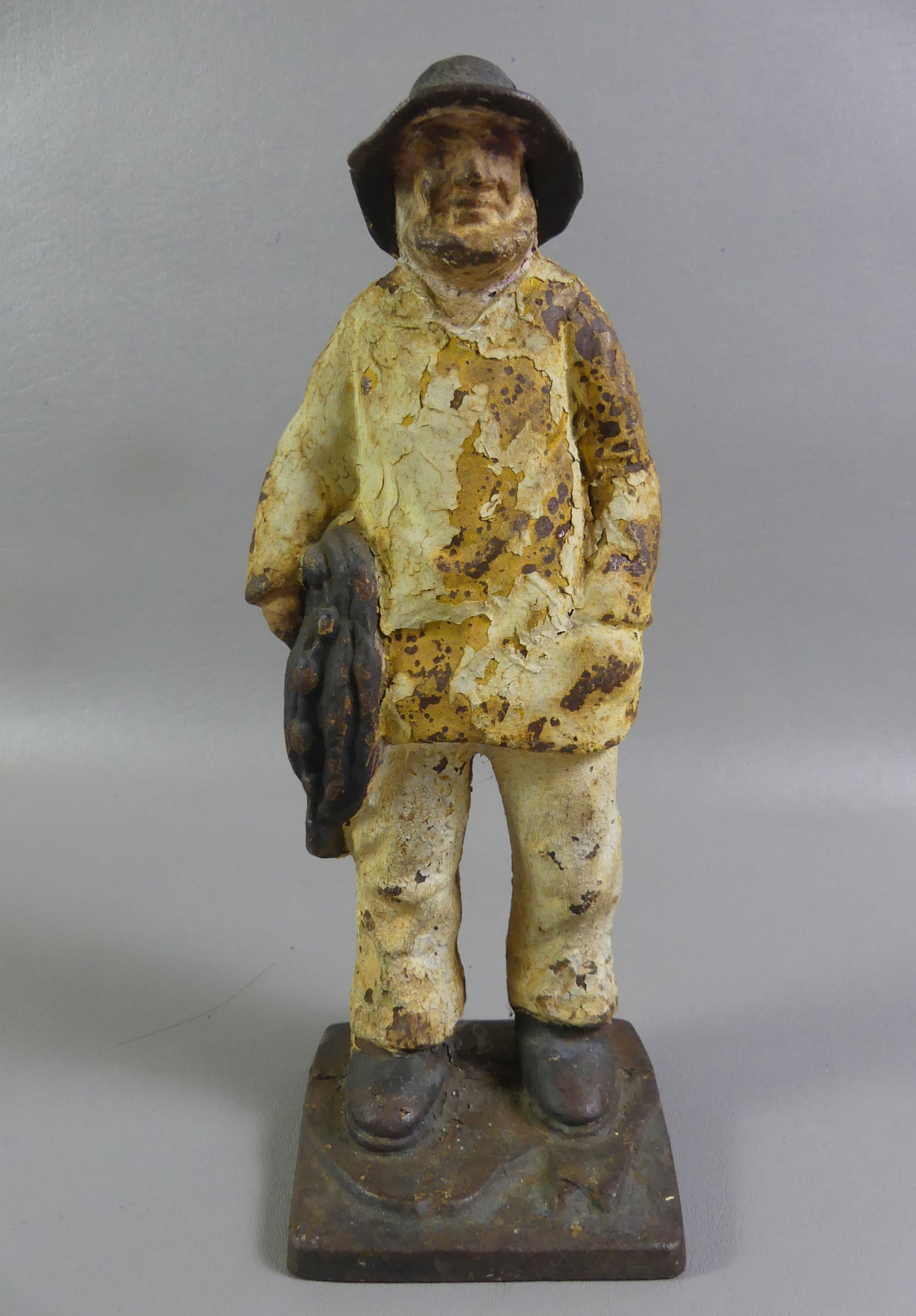 OLD SALT IRON FISHERMAN DOORSTOP: Antique painted iron doorstop of a New England fisherman holding a net. 11.5 in tall. Some rust/flaking. NOTE: We can ship this item in-house.