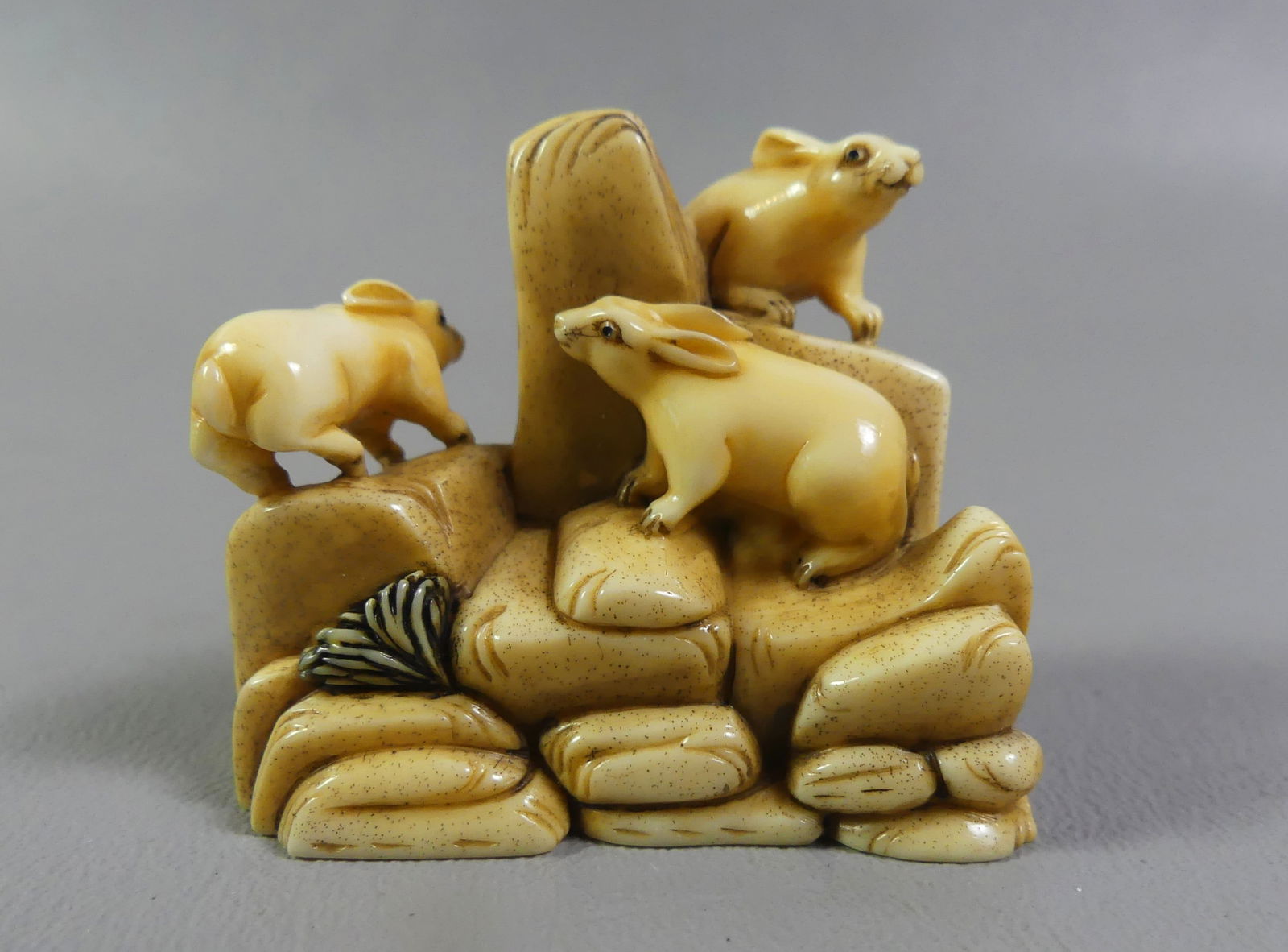 JAPANESE NETSUKE - 3 RABBITS: Antique Japanese netsuke of 3 rabbits climbing a rocky outpost. Signed. 2 x 1.5 x 1 inch. Ex-collection of Andrew C. Ware. NOTE: We can ship this item in-house.