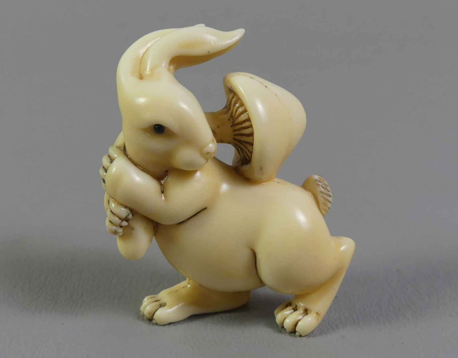 JAPANESE NETSUKE - RABBIT & MUSHROOM: Antique Japanese carved netsuke of a rabbit carrying large mushroom. Signed. 2 x 1.5 in. Ex-collection of Andrew C. Ware. NOTE: We can ship this item in-house.