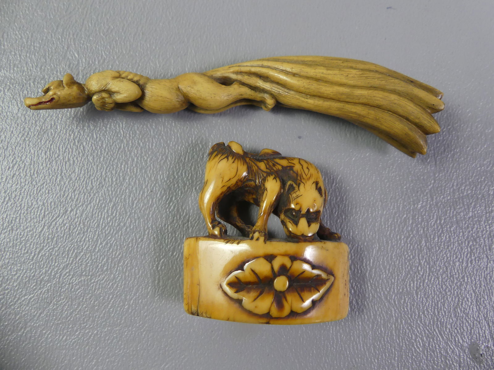 2 JAPANESE CARVED MINI FIGURES: Lot of 2 carved antique Japanese miniatures: 3.5 in animal with long cape; and an animal on floral-carved block, 1.5 x 1.5 in. Unsigned. Ex-collection of Andrew C. Ware. NOTE: We can ship this item