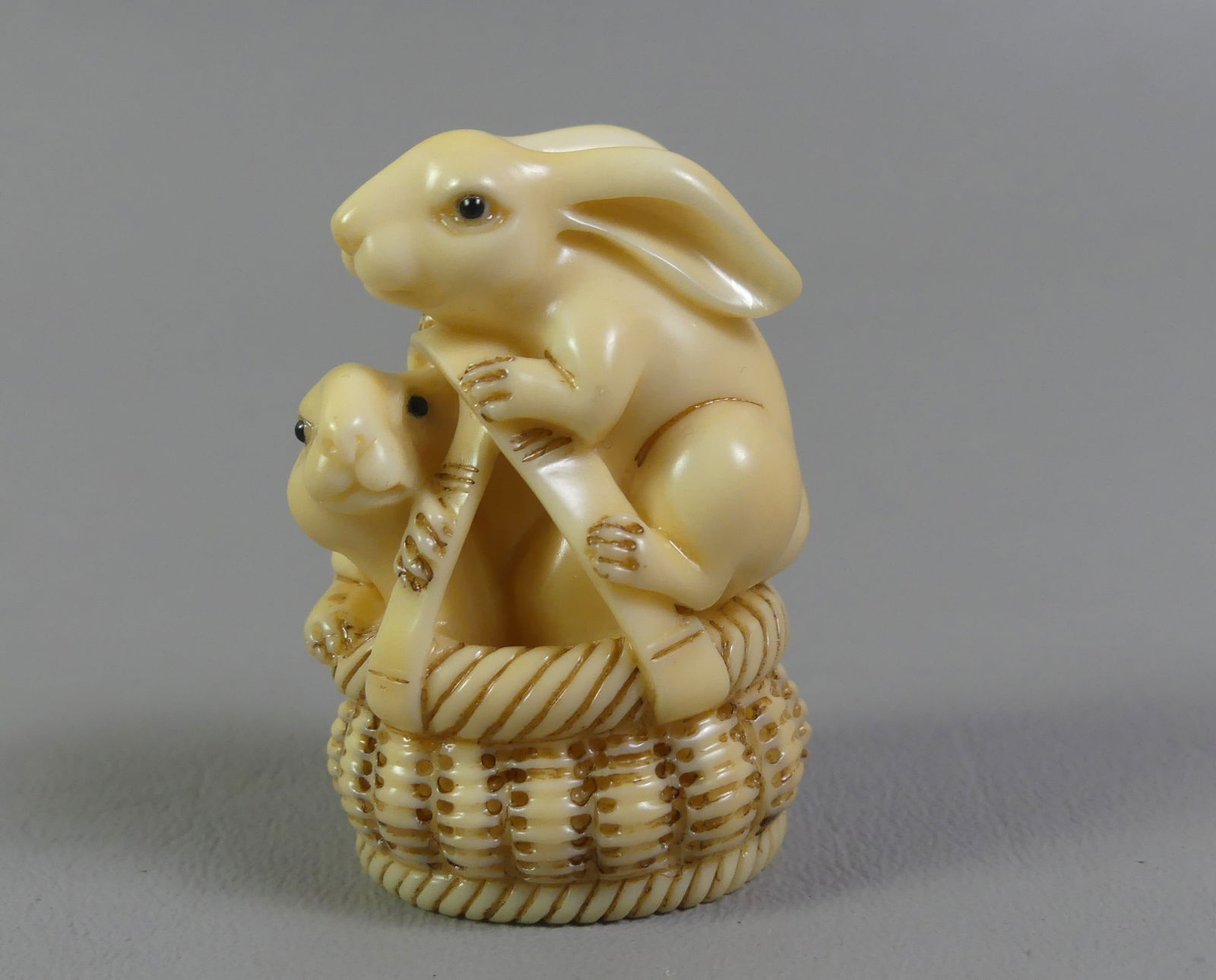 JAPANESE NETSUKE - RABBITS IN BASKET: Japanese carved netsuke of 2 rabbits in a woven basket. Size: Ex-collection of Andrew C. Ware. NOTE: We can ship this item in-house.
