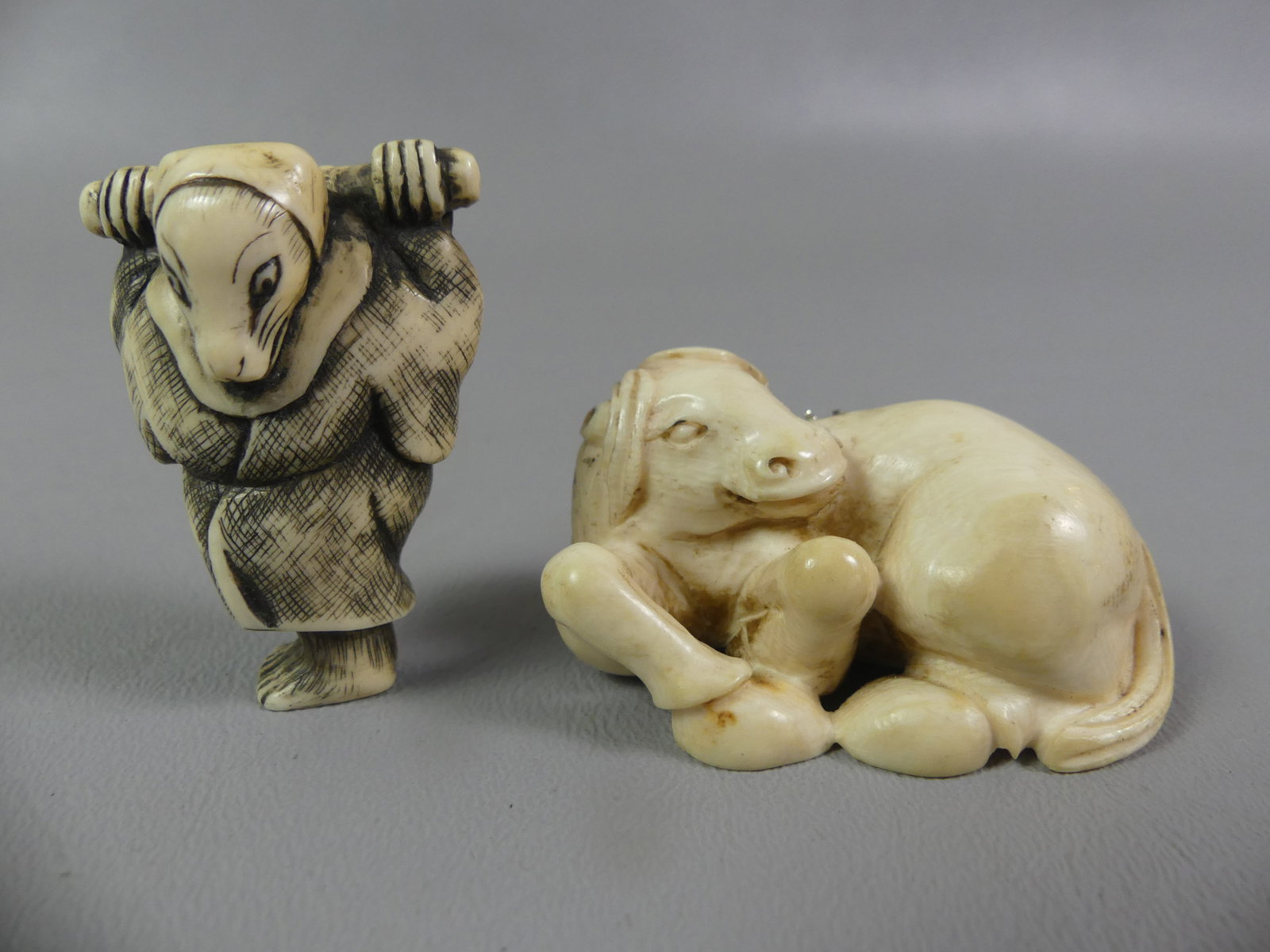 2 JAPANESE NETSUKES - HORSE & ANIMAL: Lot of 2 antique carved Japanese netsukes: reclining horse, 2 x 1 in; and animal holding bar on back of neck, 1.75 in high. Both unsigned. NOTE: We can ship this item in-house.