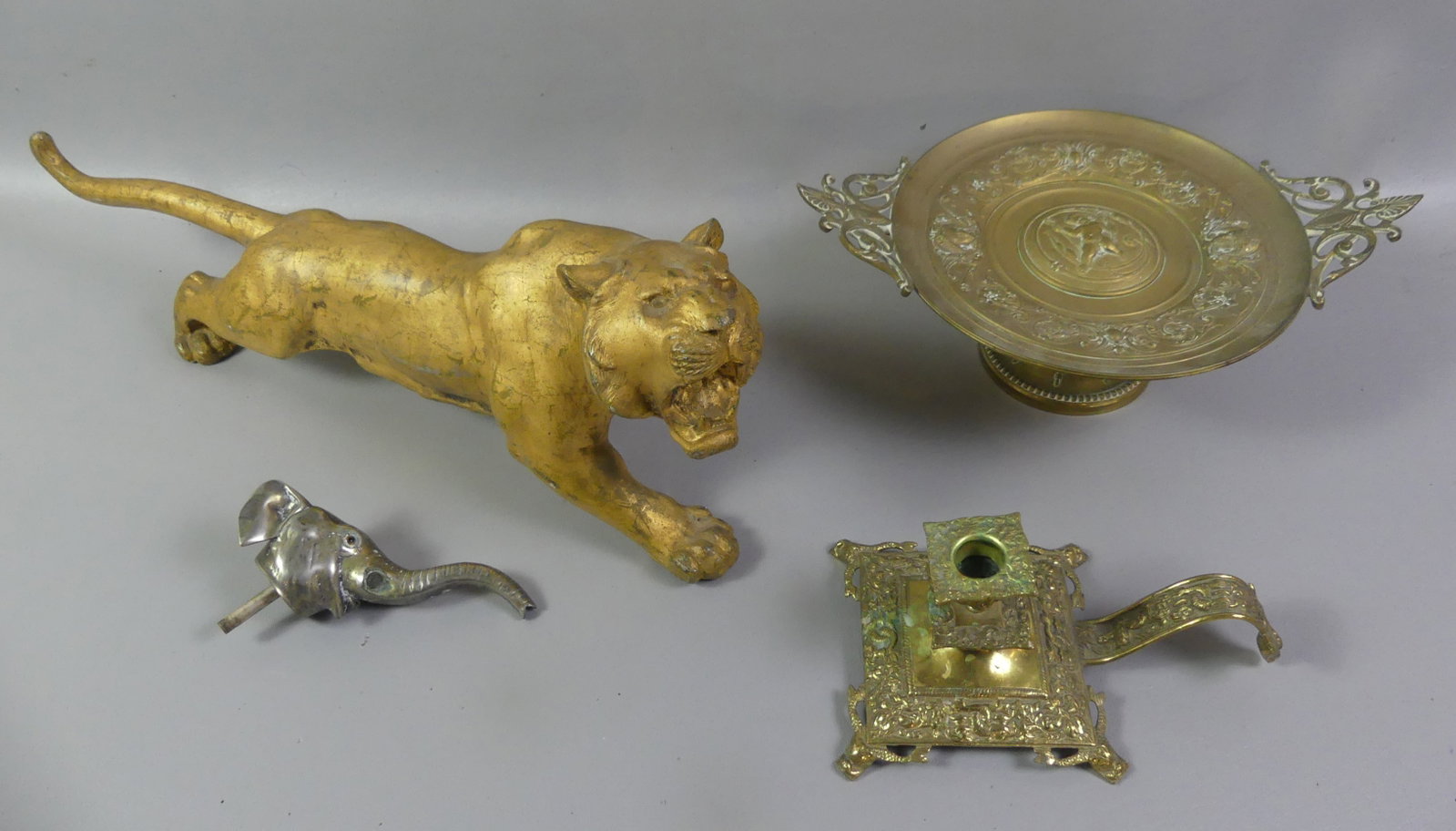 4 OLD METAL ITEMS: TAZZA, TIGER, ETC.: Lot 4 old/antique metal items: 21 x 7 inch gilt metal tiger; 14 in diameter Victorian bronze tazza with cherub; brass chamberstick with sea life; and 6 in elephant head stopper. Note: We can ship