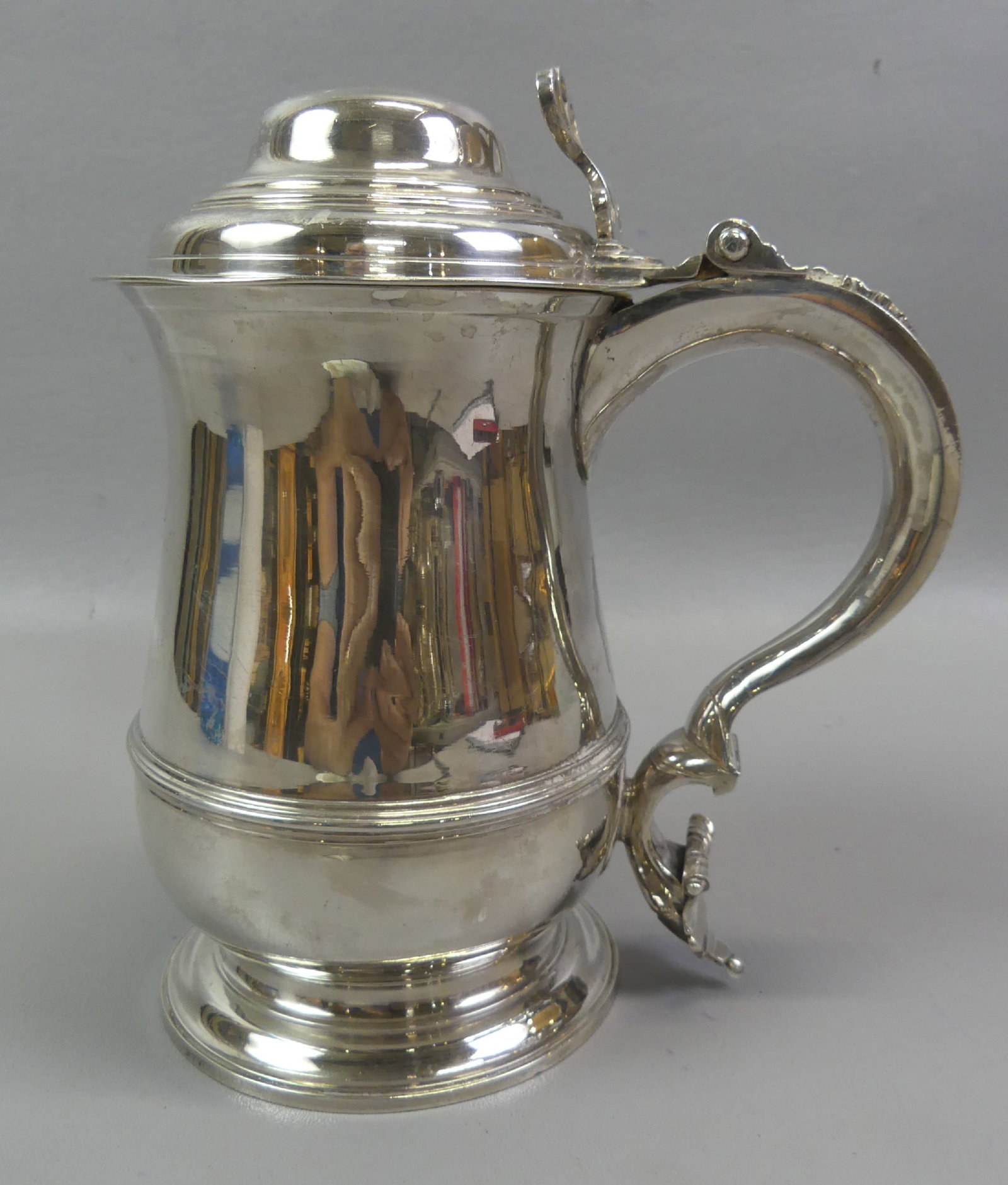 1760 GEO. III STERLING TANKARD: Fine English George III sterling silver lidded tankard with hallmarks for London, 1759/1760, maker RC. It has a gilt interior and body has engraved coat-of-arms and monogram. Fancy openwork thumb