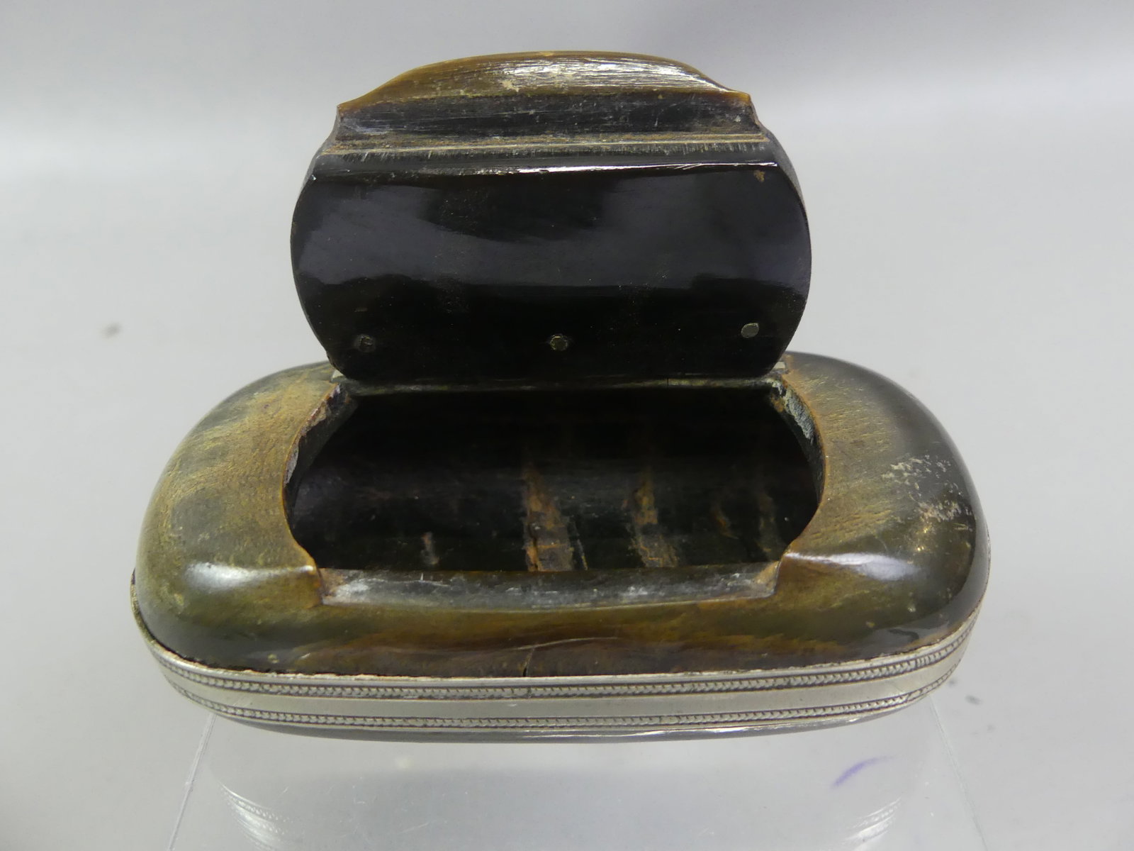ANTIQUE HORN & SILVER SNUFF BOX: 19th century cow horn and silver-mounted snuff box with hinged lid attributed Scottish. 3.5 x 1.75 x 1 in thick. Good condition, no marks.