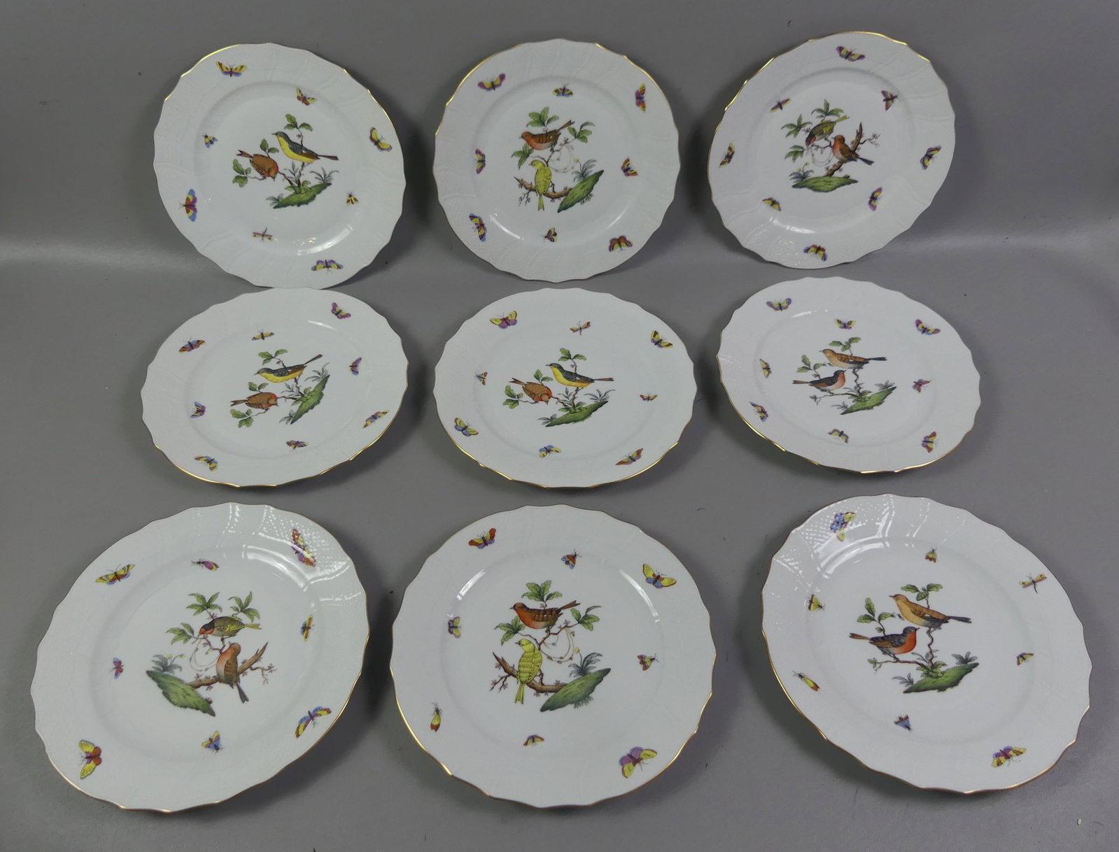 SET 9 HEREND ROTHSCHILD BIRD DINNER PLATES: Set of 9 vintage Herend of Hungary hand painted dinner plates in the Rothschild Bird design having colorful birds and insects. They have a scalloped and gilt rim with basketweave design, #1524. 10.25