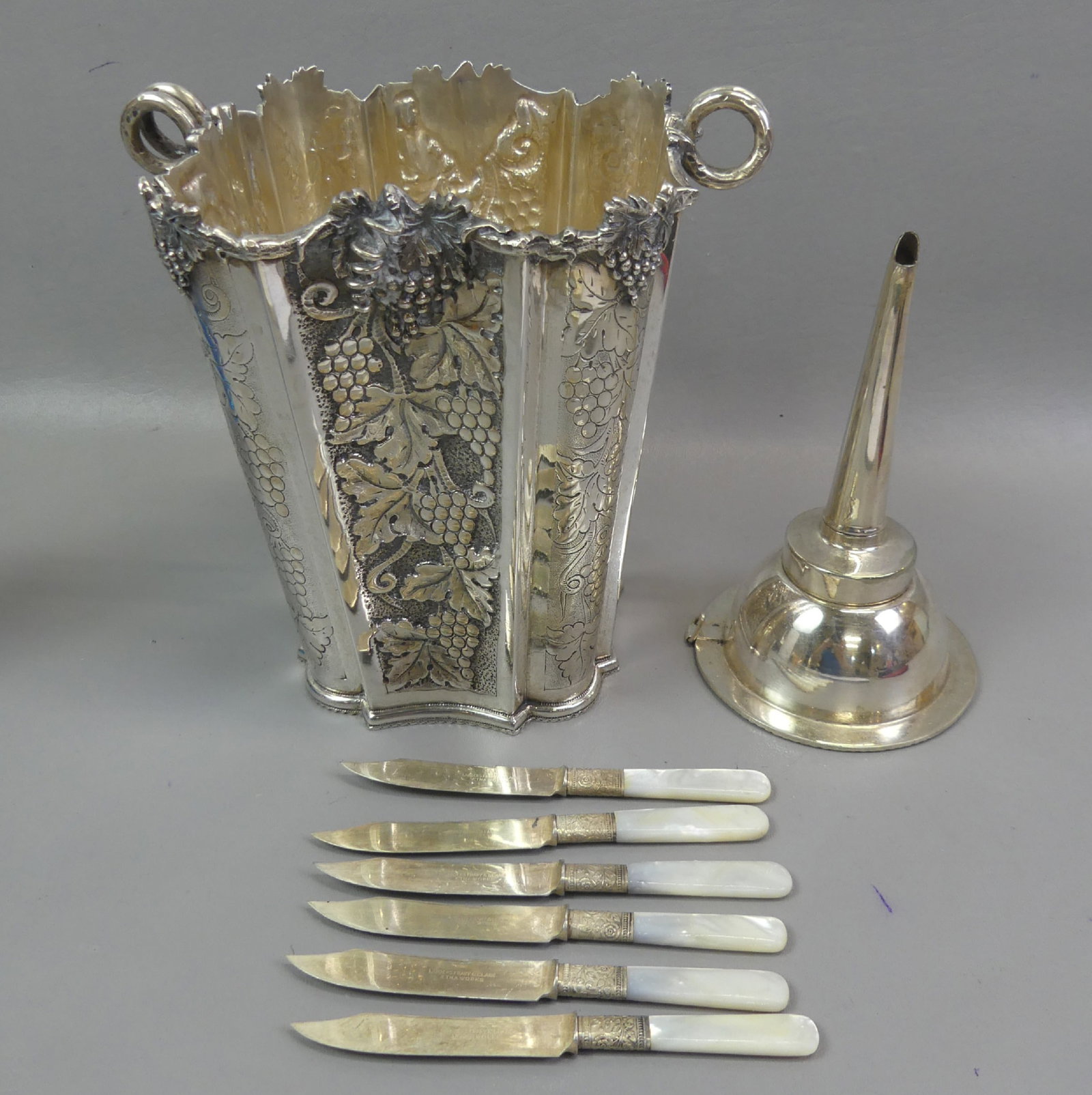 .800 SILVER WINE COOLER & ACCESSORIES: Lot including a fine Italian .800 silver wine cooler / champagne bucket with insert having rococo grape designs and weighs 51.75 ozt. Hand made with illegible maker mark; Plus a silver plated 2-part w