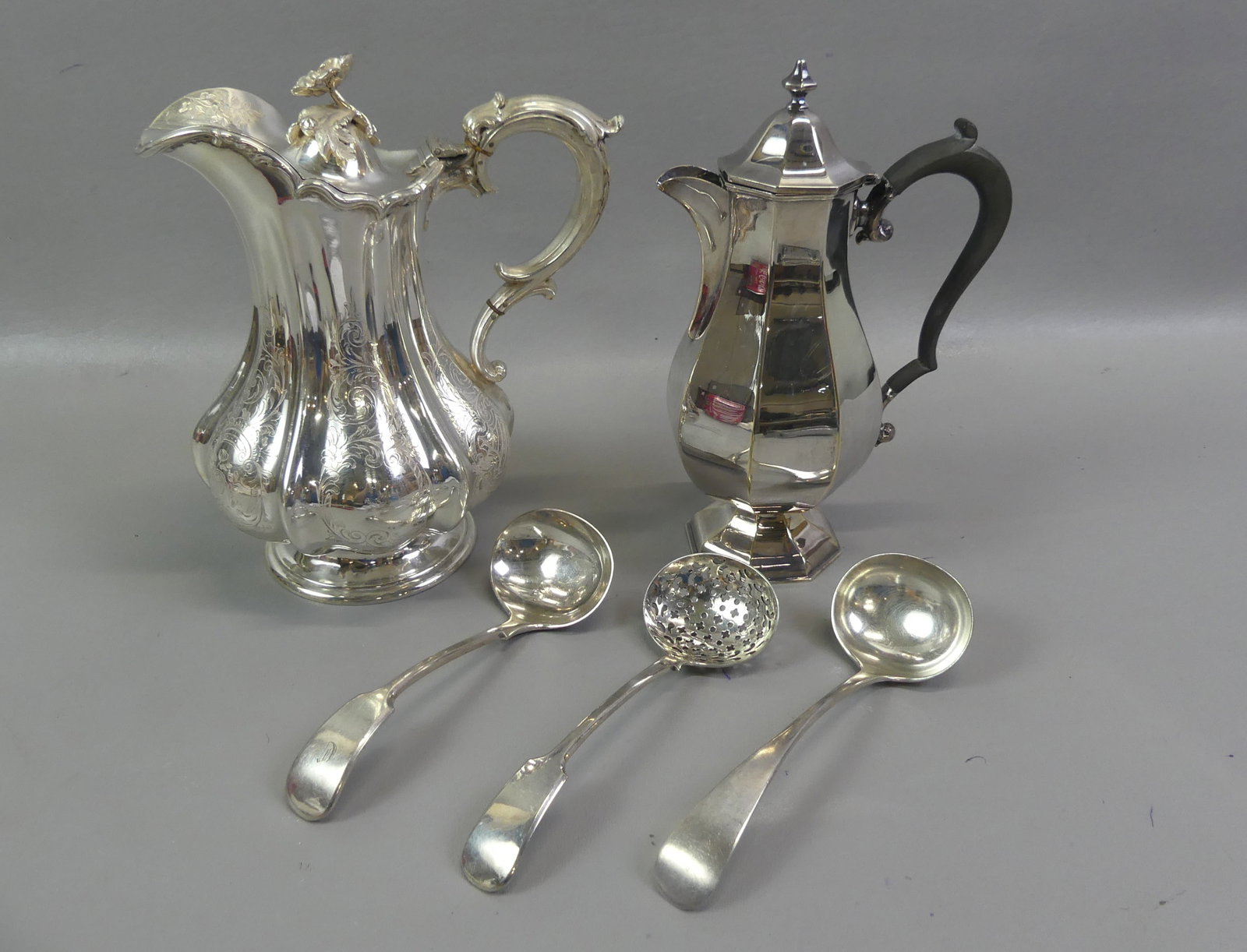 5 PCS. SILVER PLATED TABLE ITEMS: Lot of silver plated items including 2 teapots to 9.5 in, one fancy Victorian and other in a paneled design; and 3 serving spoons.