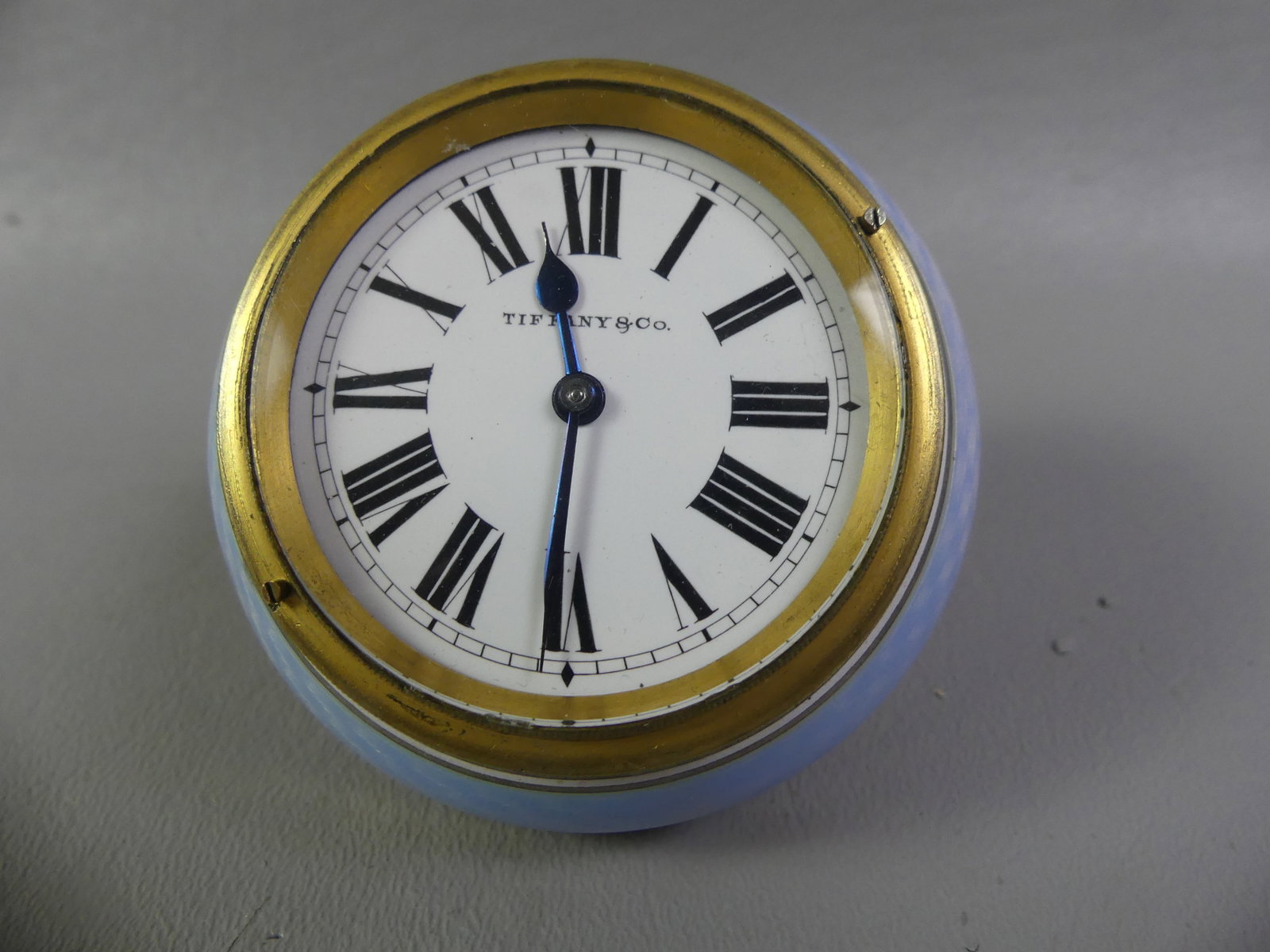 TIFFANY SILVER & ENAMEL DESK CLOCK: Rare early 20th century Tiffany & Co. round, parcel gilt silver desk clock with powder blue enameled guilloche trim. This is a bezel set and wind 8 day clock with 1.75 in dial. Overall 2.75 in