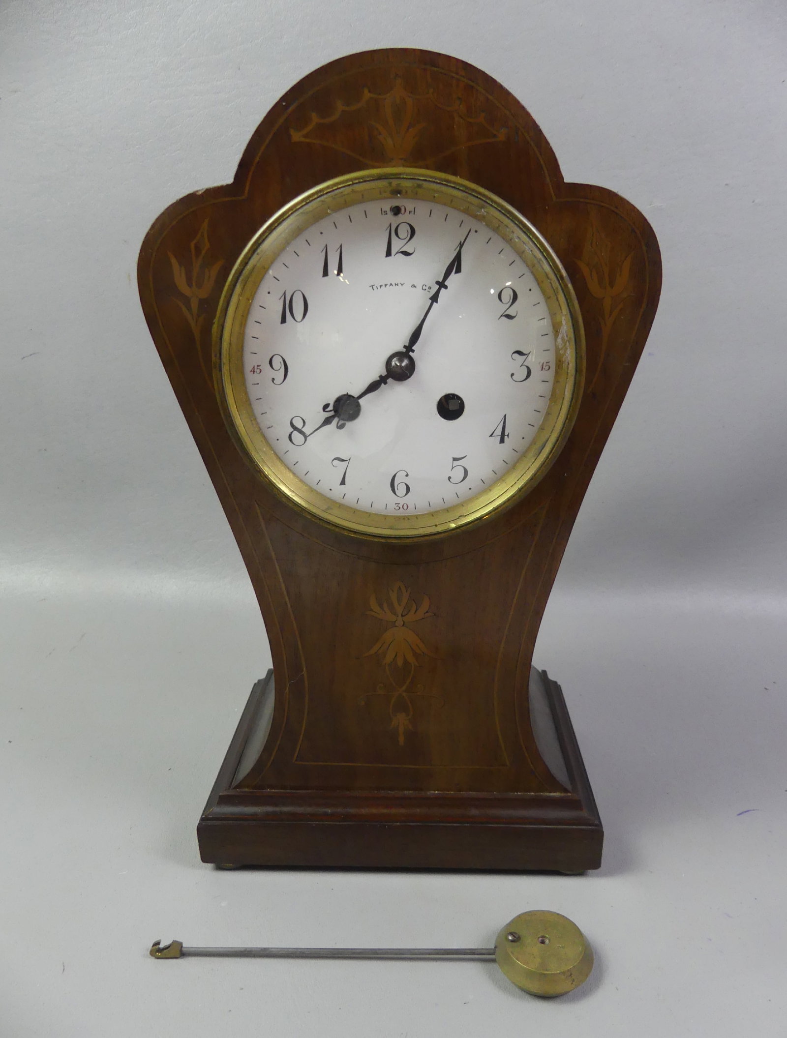 TIFFANY INLAID FRENCH MANTLE CLOCK: Inlaid mahogany mantle clock with enameled white 4.5 in dial signed Tiffany and Co. Brass movement stamped by S. Marti of Paris and Tiffany. 12.5 in tall, has pendulum, 8 day time and strike.